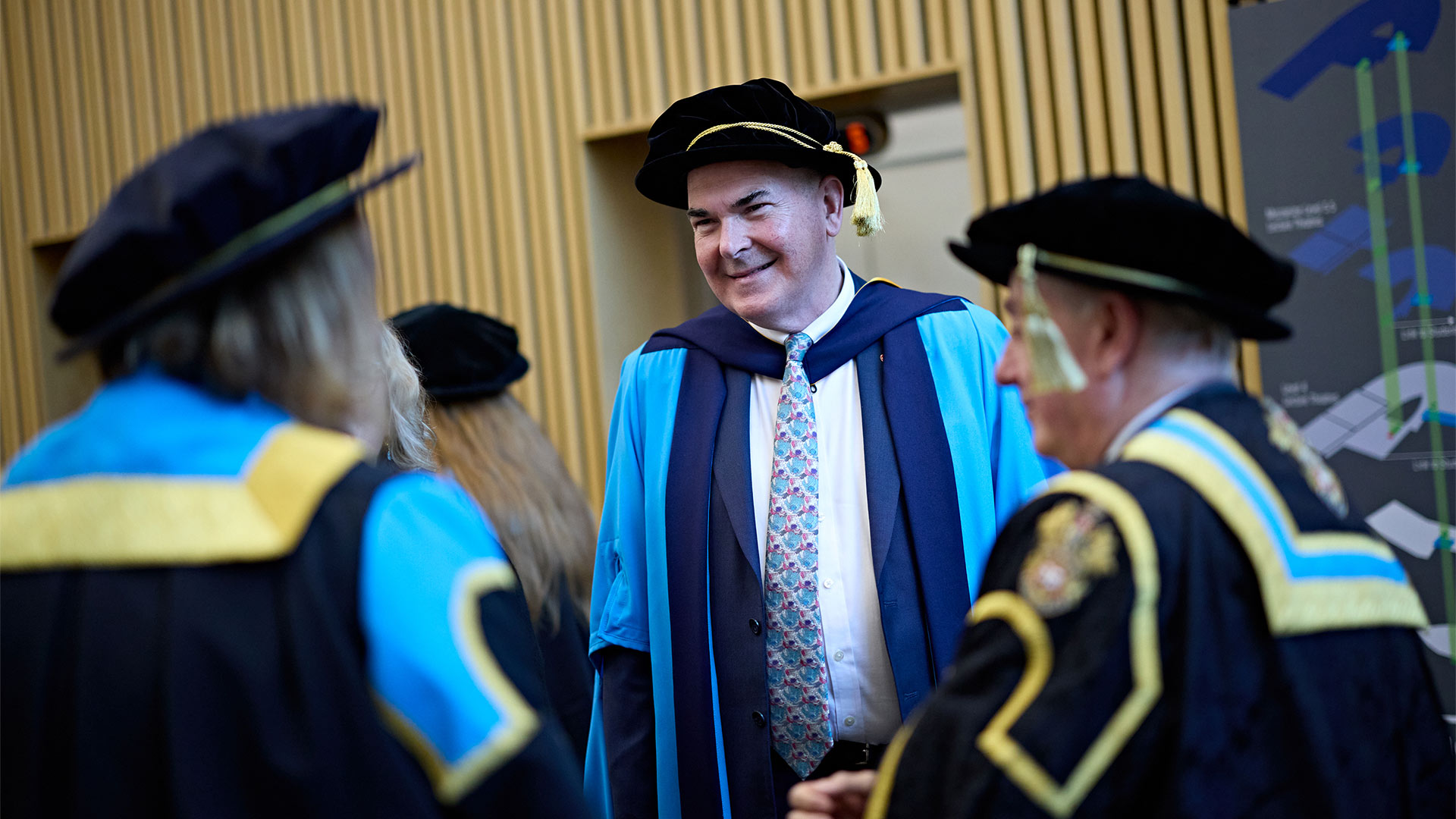 A group of people outside a graduation ceremony wearing gowns