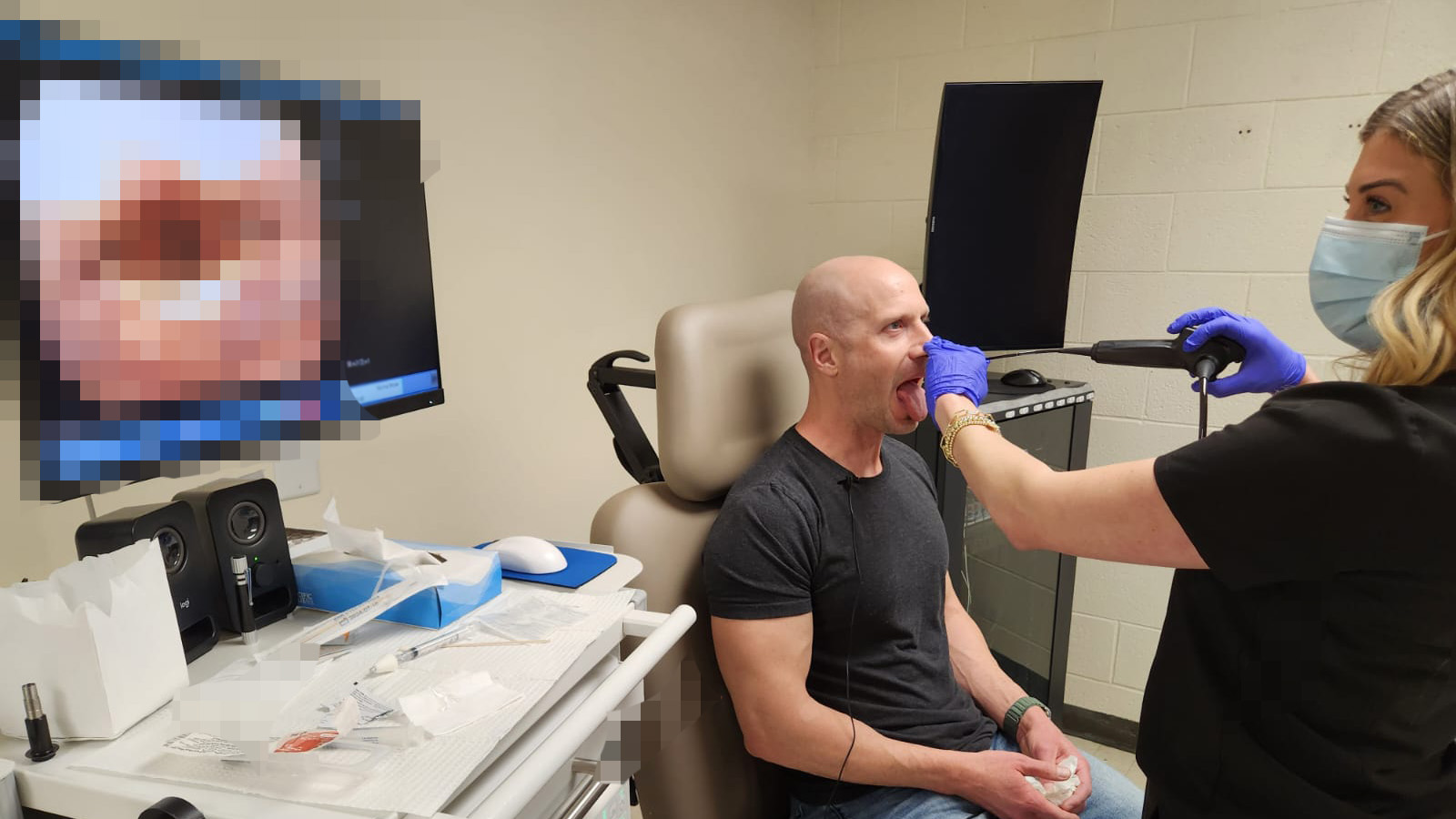 A singer has his vocal cords assessed by a tiny camera with a screen showing a pixelated image behind him