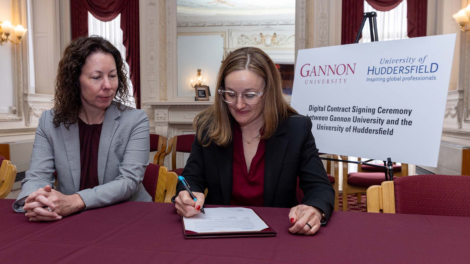 Two academics signing a memorandum of understanding