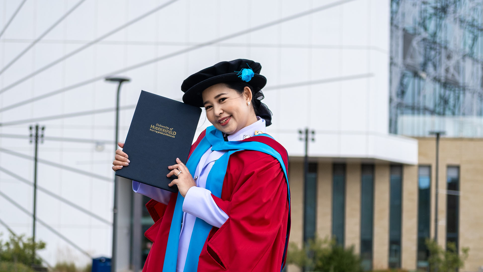 Nutthika with PhD in front of the University of Huddersfield