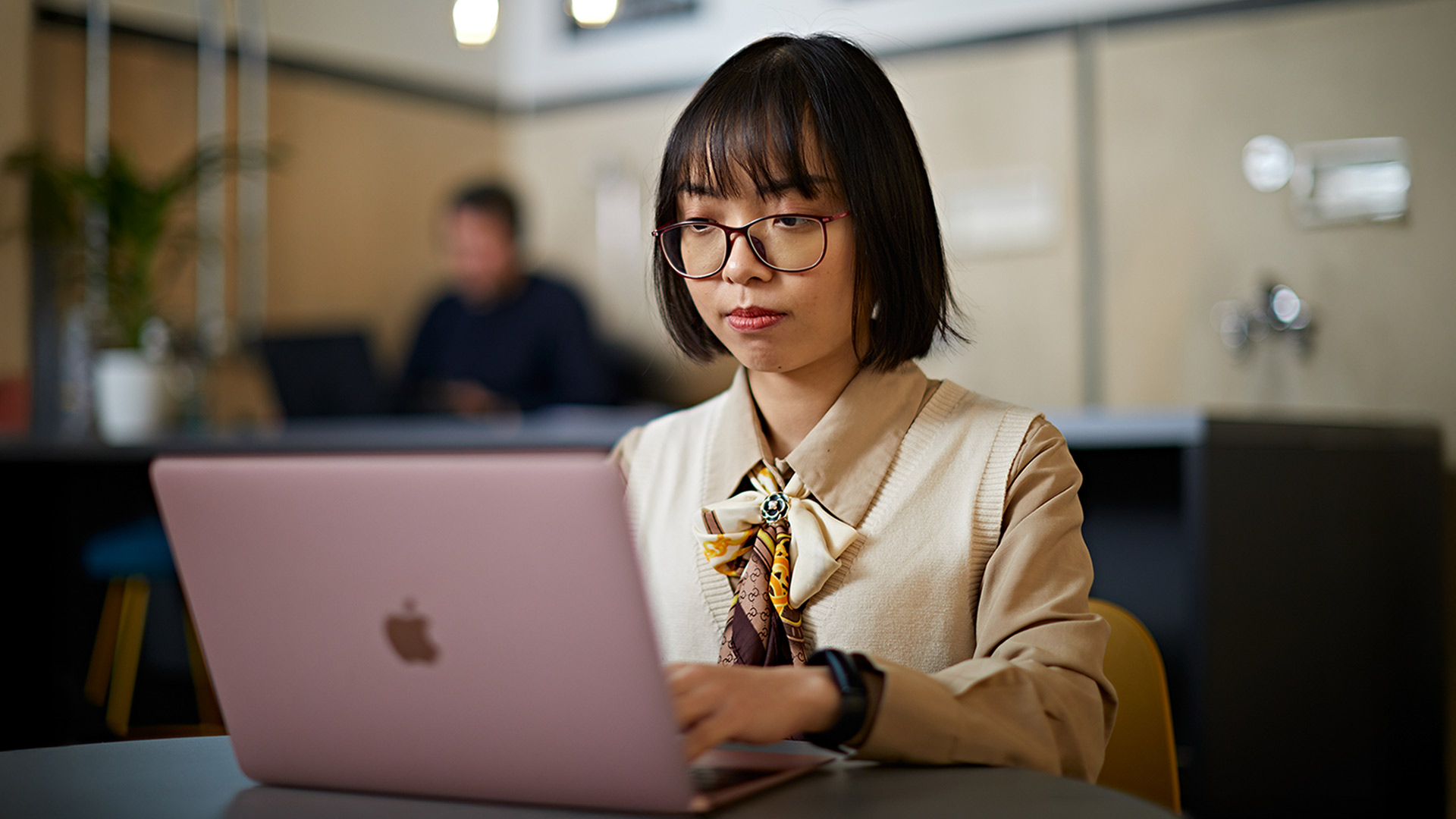 A person working at a laptop in a cafe