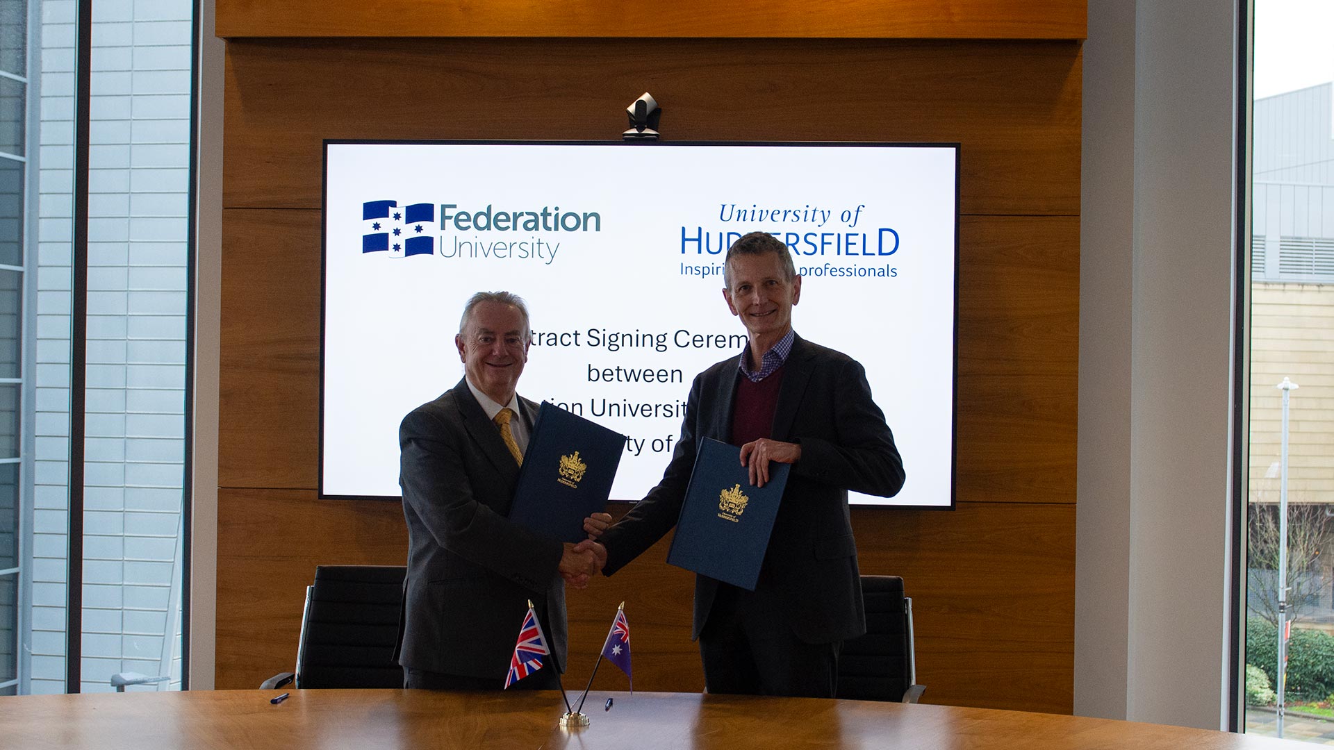 Two men standing in a board room shaking hands
