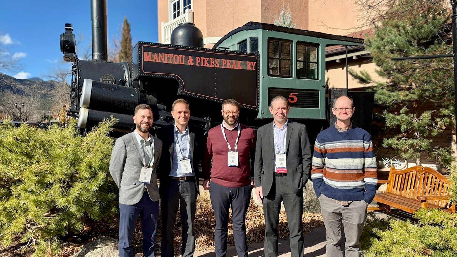 A group of men stood infront of a historic train