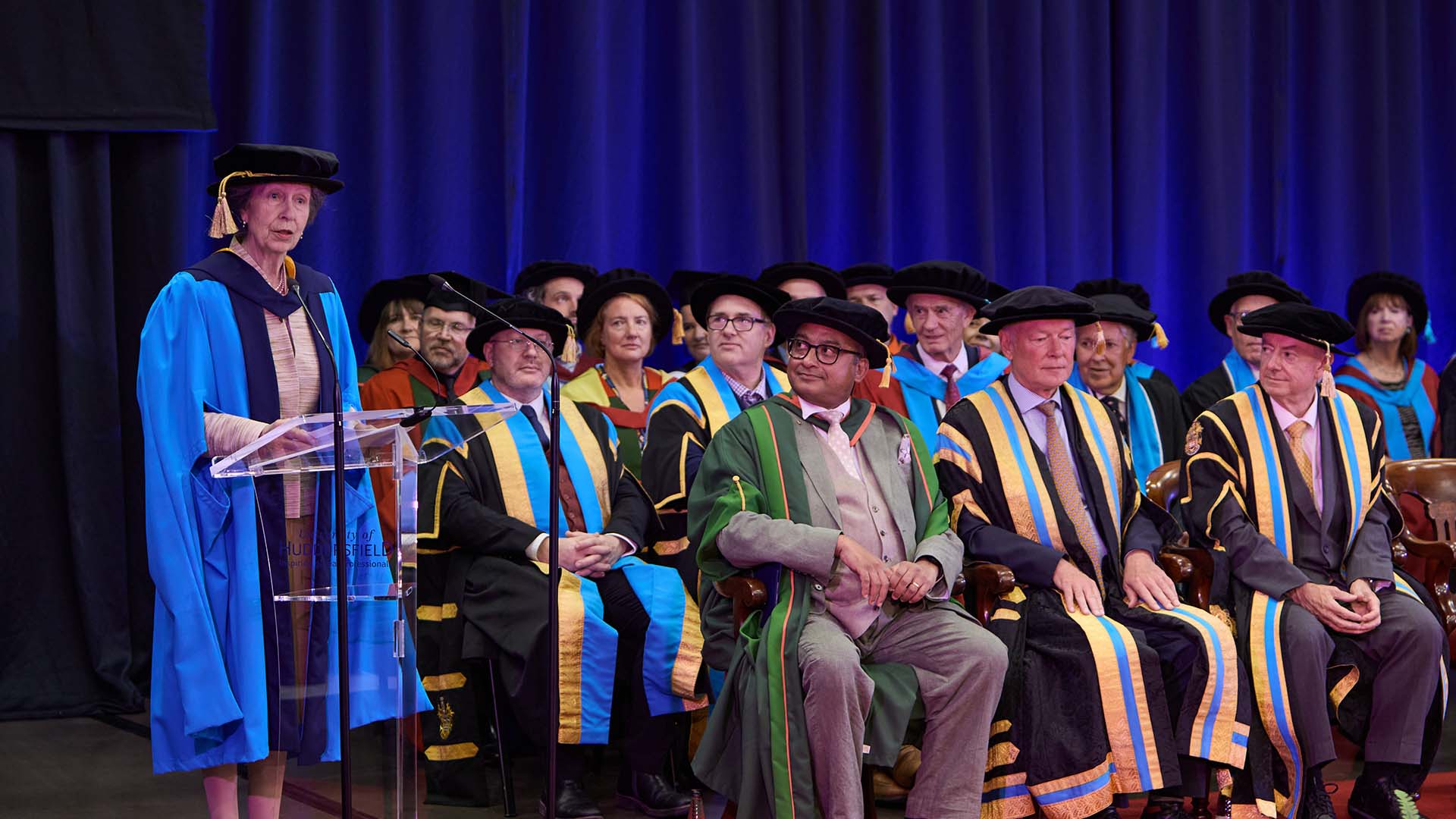 The Princess Royal speaking at a graduation ceremony on stage with University of Huddersfield academics