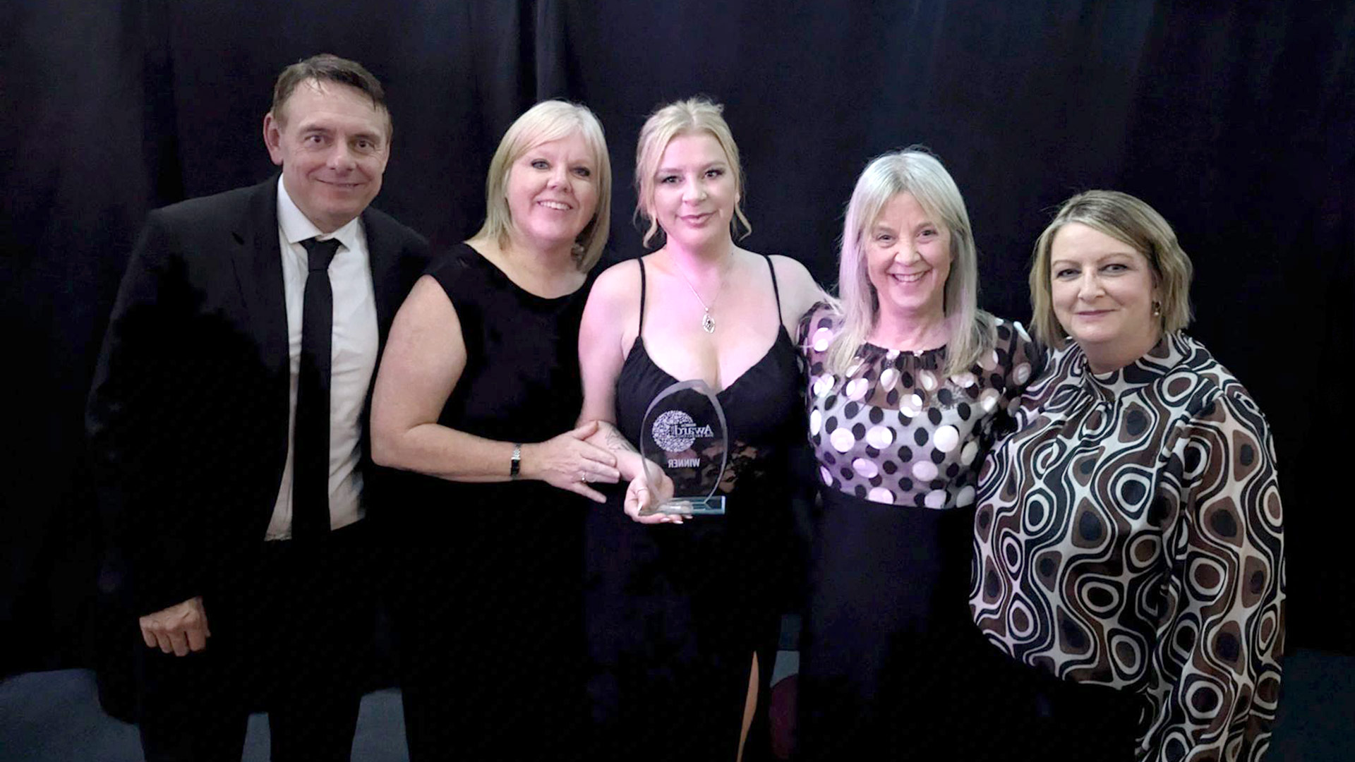 Dr Jessica Senior receiving an award with a group of people