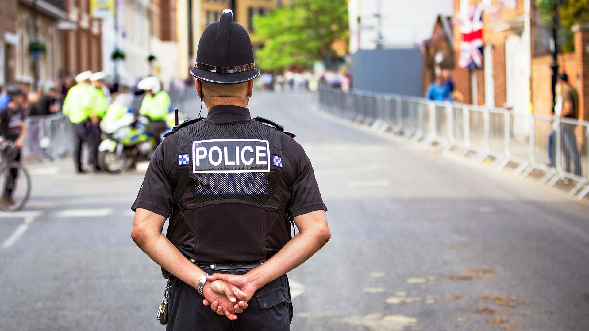 A police officer stands with their back to the camera