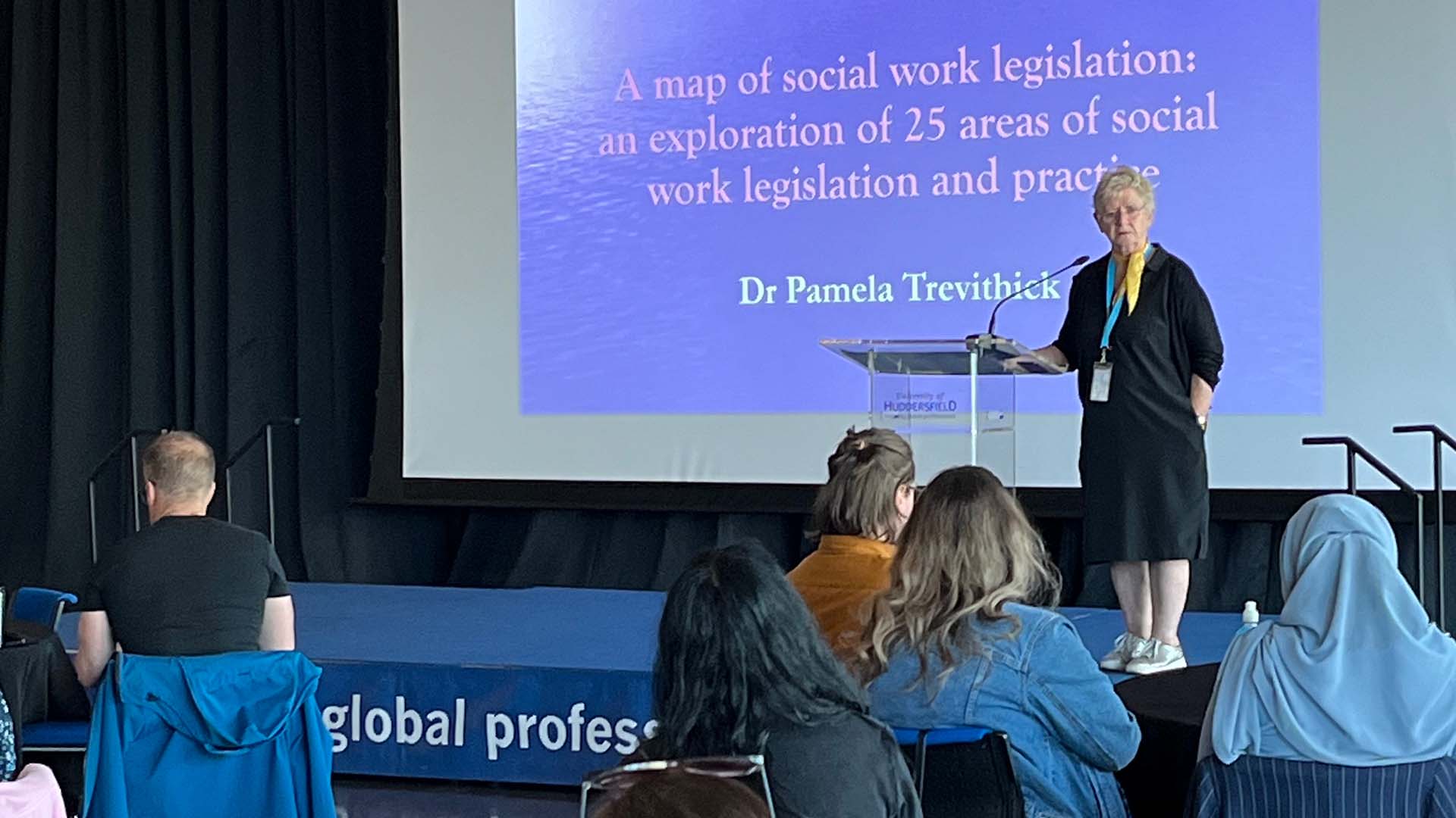 Pam Trevithick speaks to a conference from a stage
