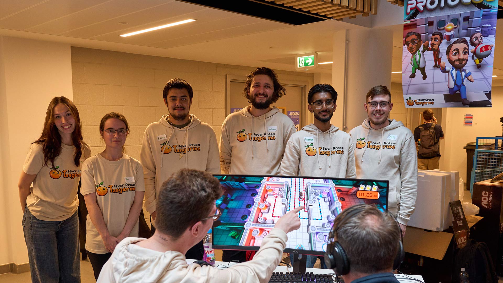 a group of students showing off a game on a PC