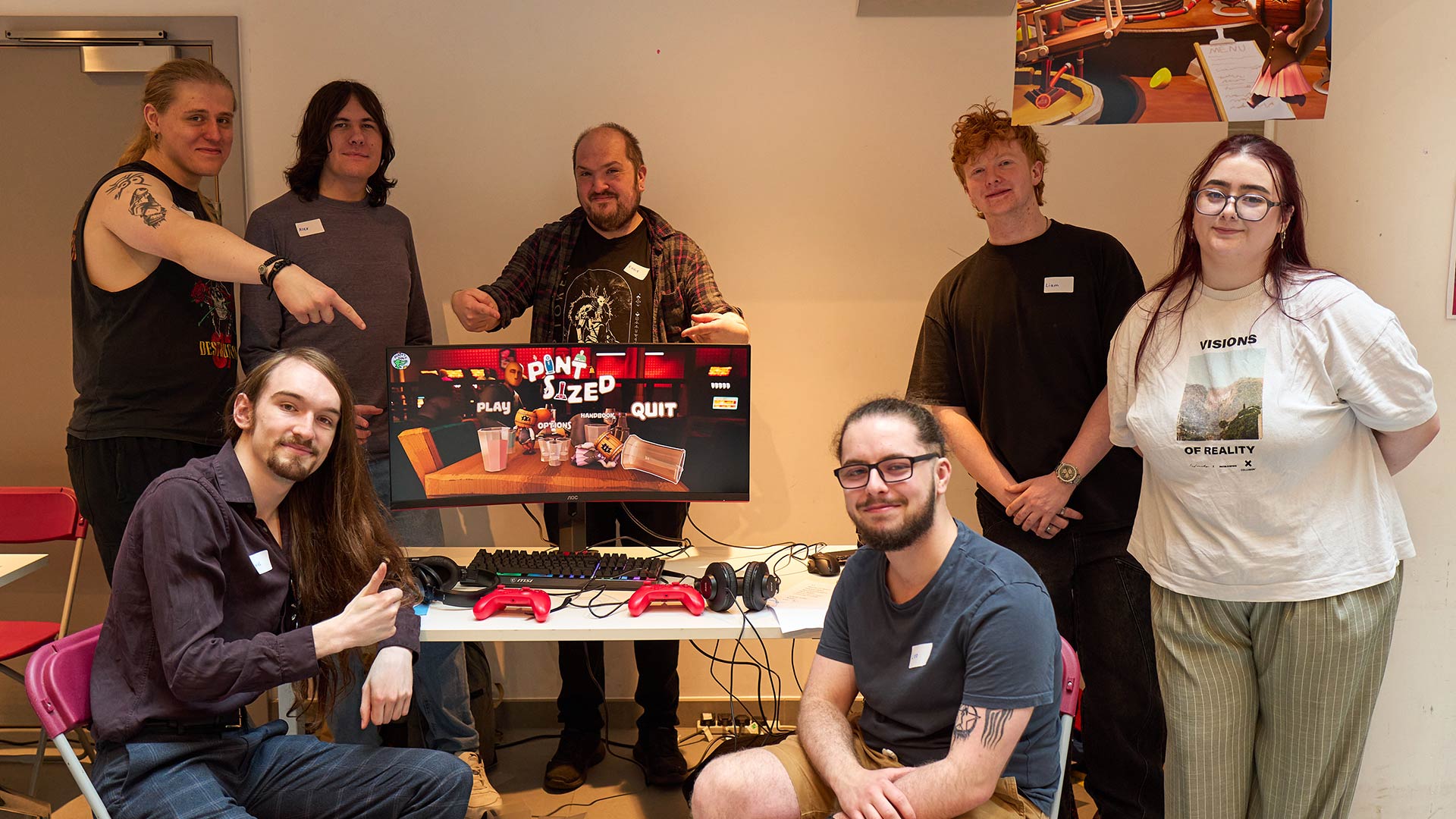 a group of students showing off a game on a PC