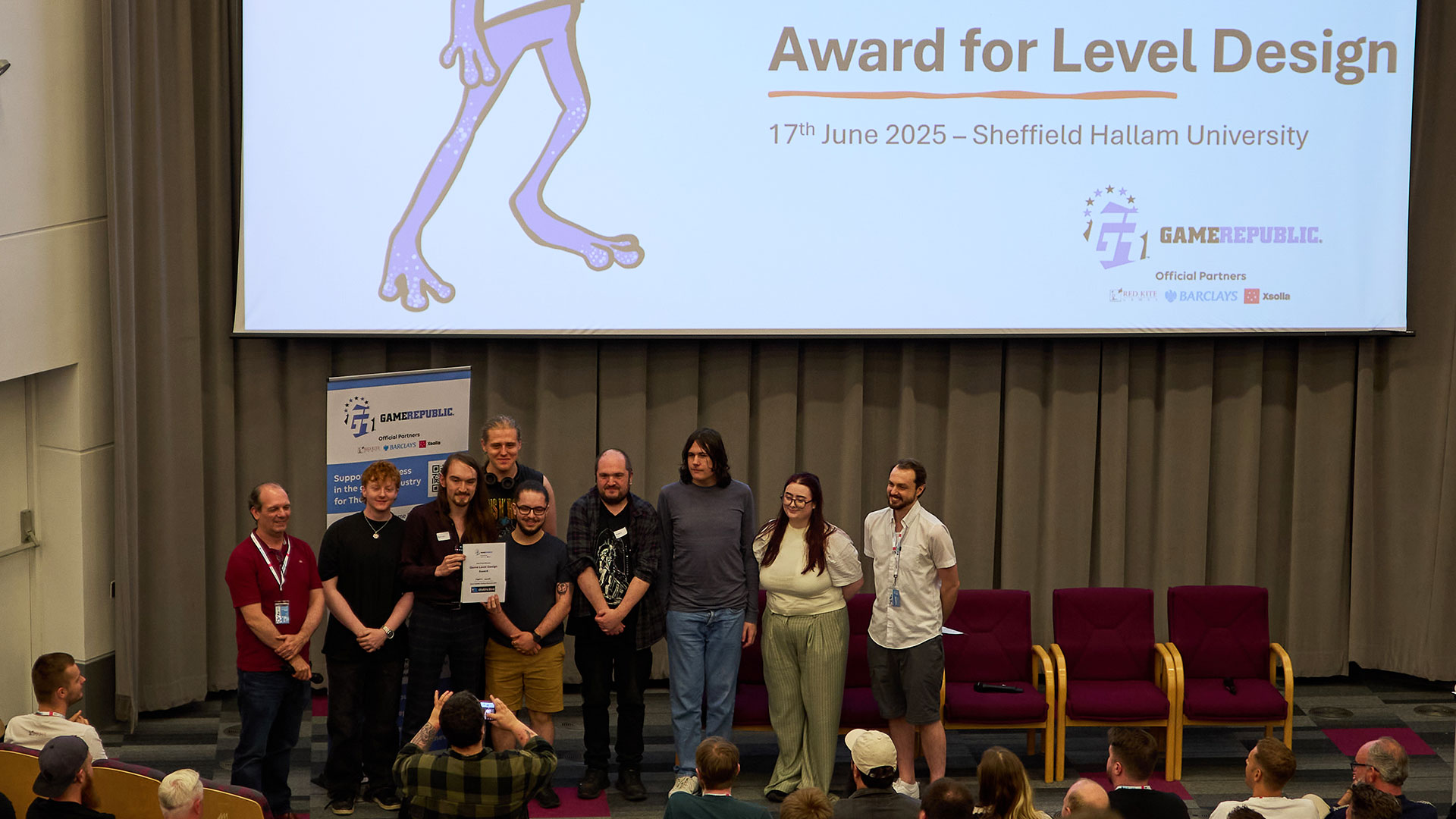 A group of students on stage picking up an award