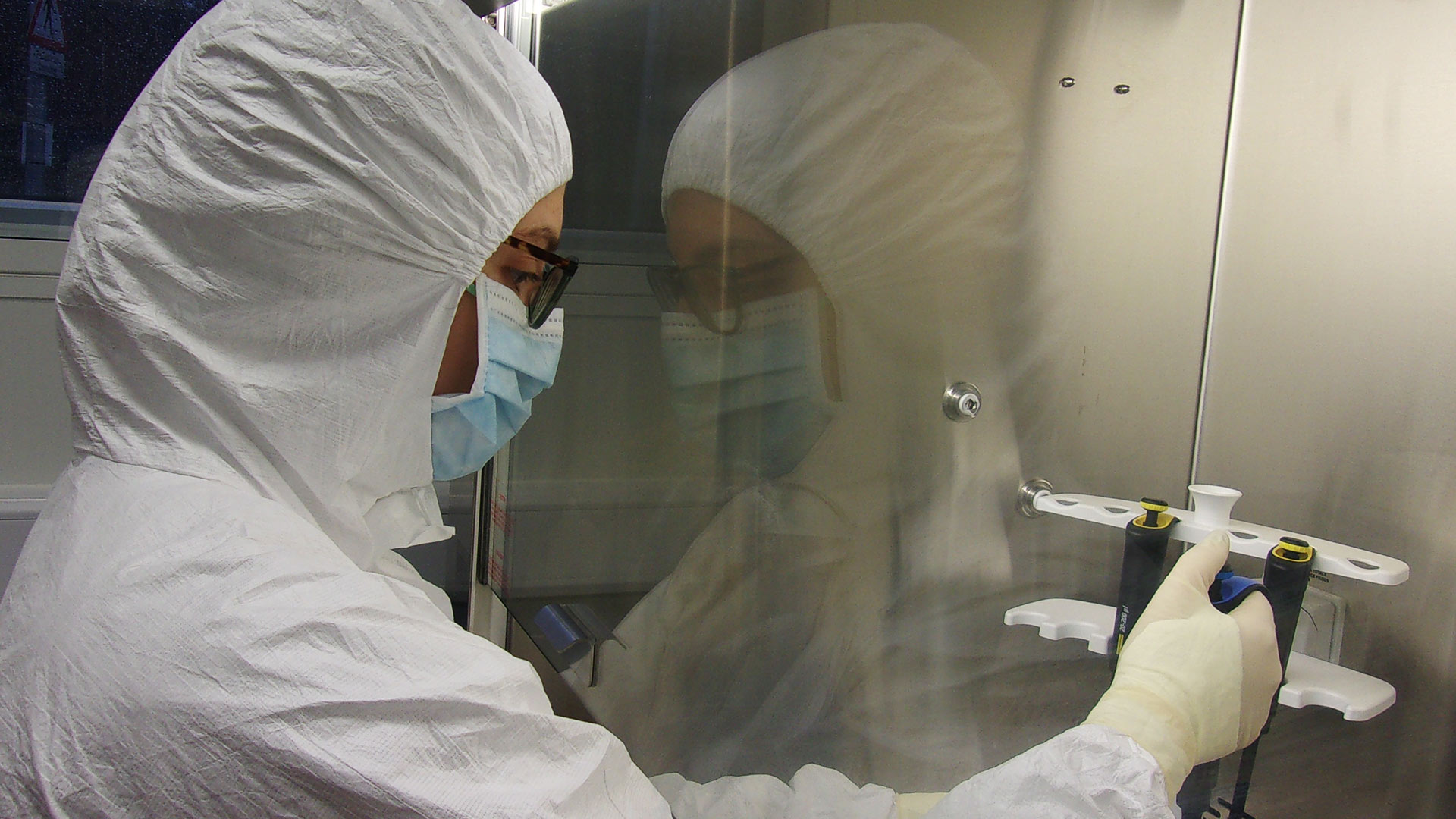 A person in protective clothing and mask using the ancient DNA lab