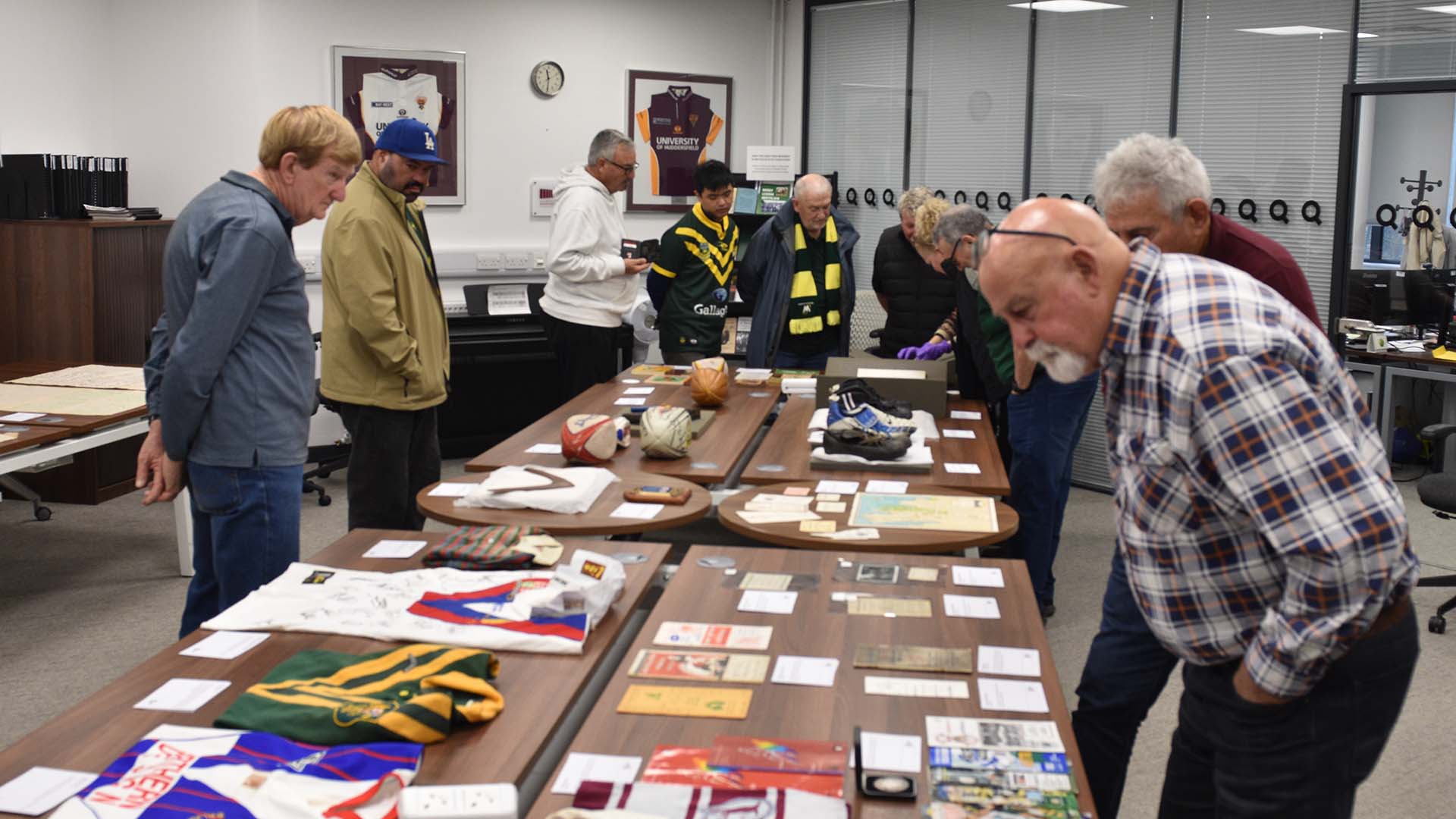 Australian rugby league fans look at a table with rugby league artefacts