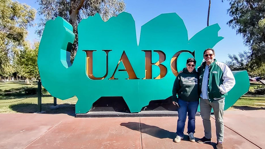 Camilo Tamayo Gomez at UABC in front of the sign outside the university