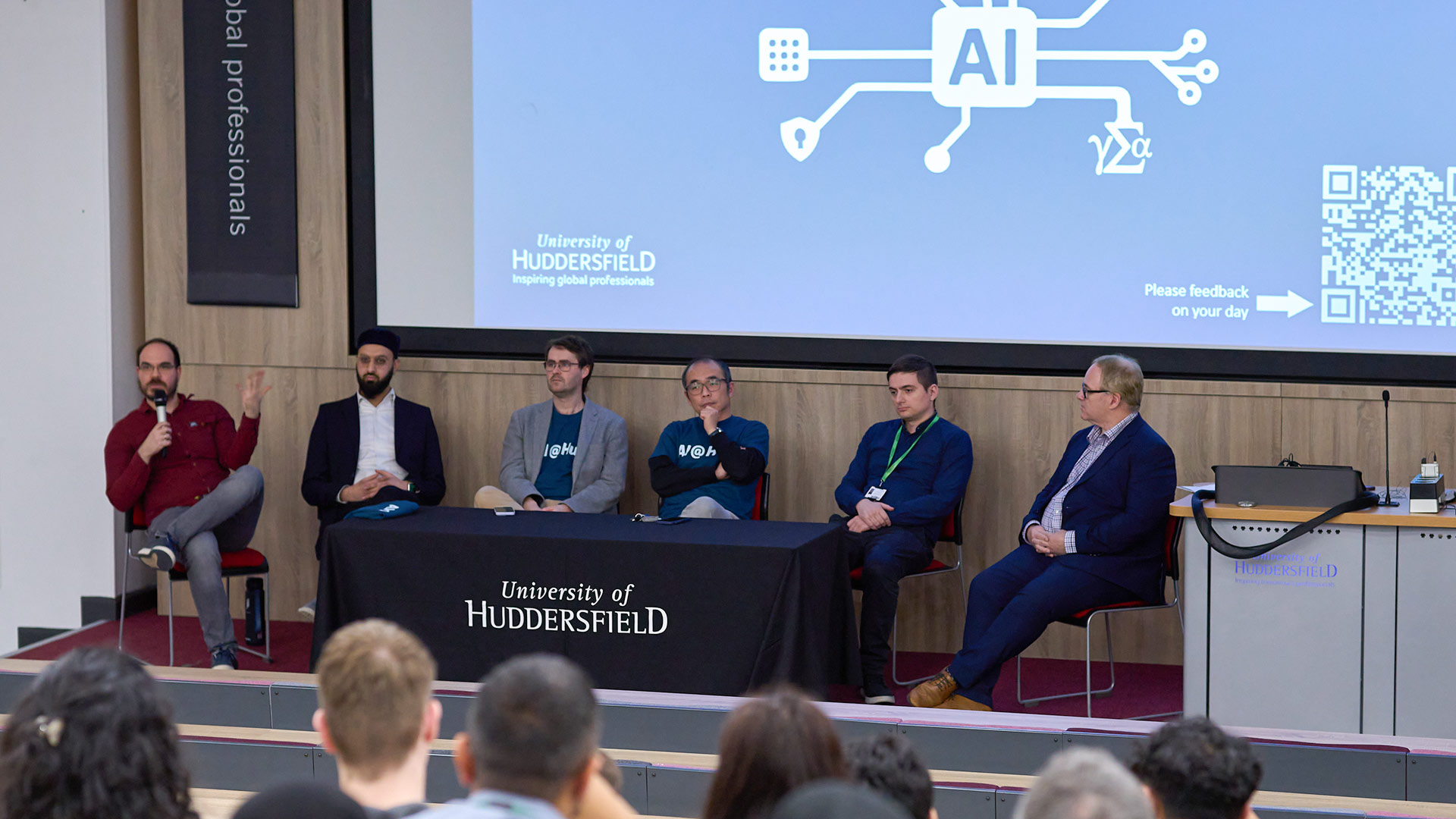 AI experts sitting on a stage as part of a panel at a conference