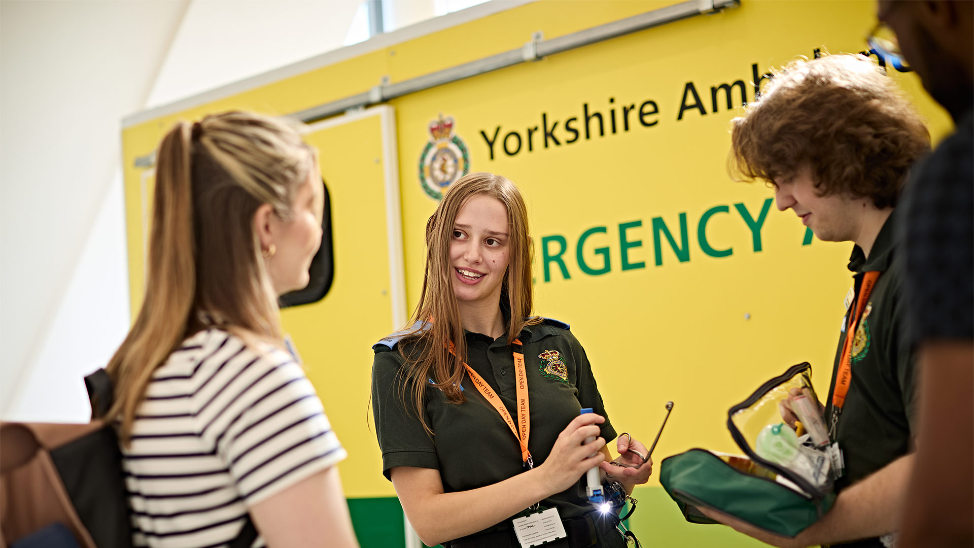 A student talking to two other people in front of an ambulance simulator