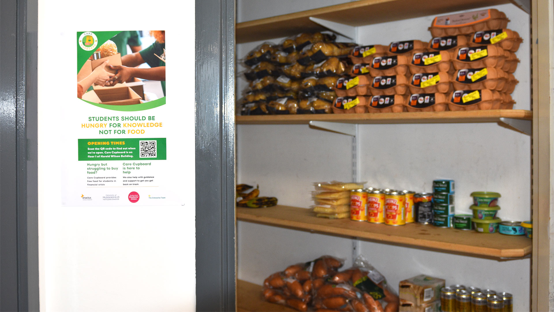 An open cupboard with shelves stocked with food items