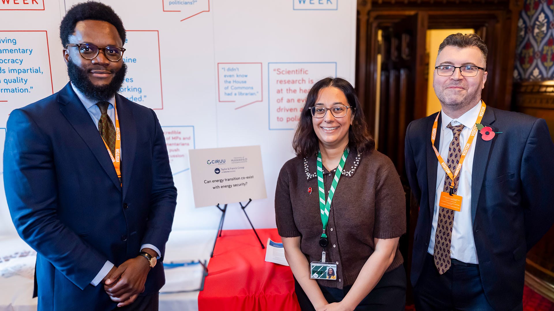 Three people stood infront of a stand at an event