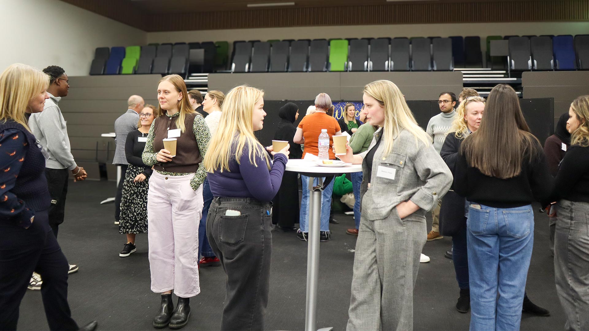 A group of students with businesspeople gathered in a conference room