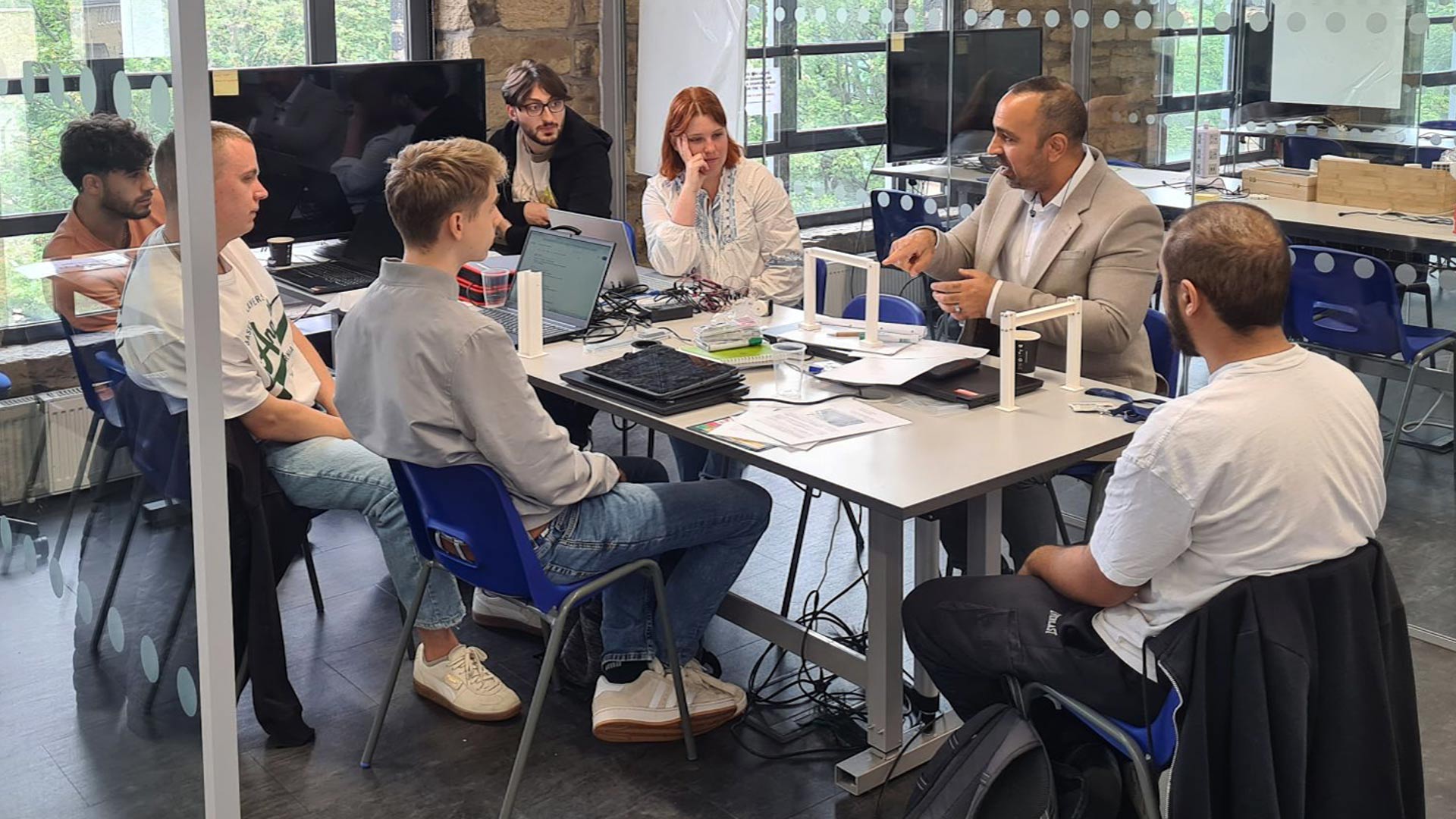 students sat around a table working on an engineering problem