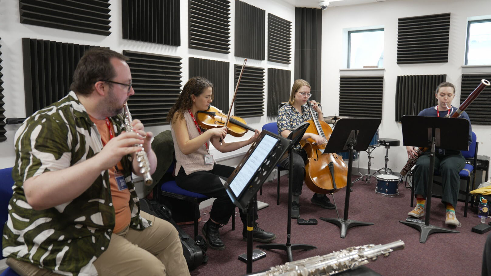 Musicians playing wind and string instruments while sat down