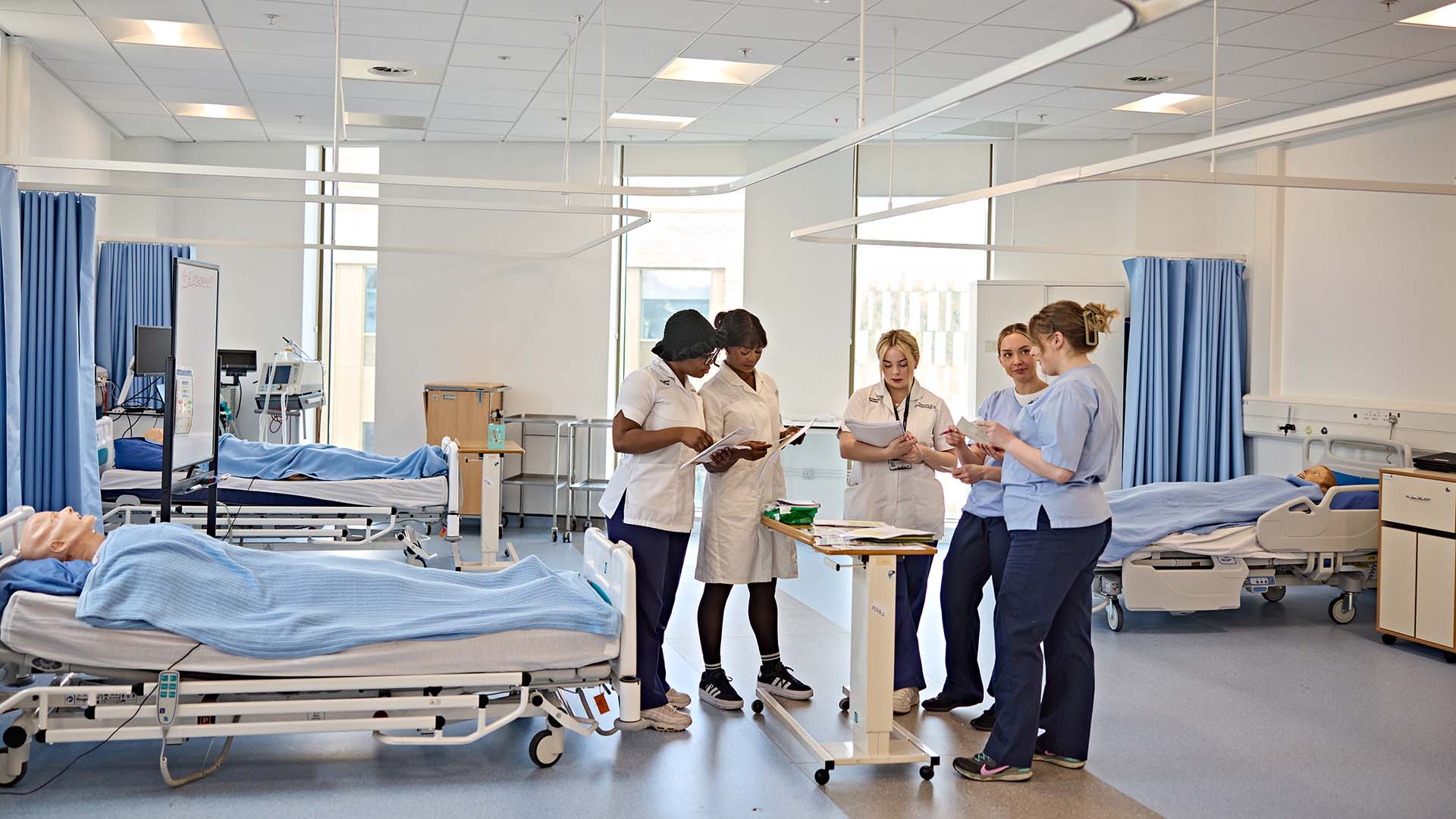 A group of nursing students in a mock-up hospital ward