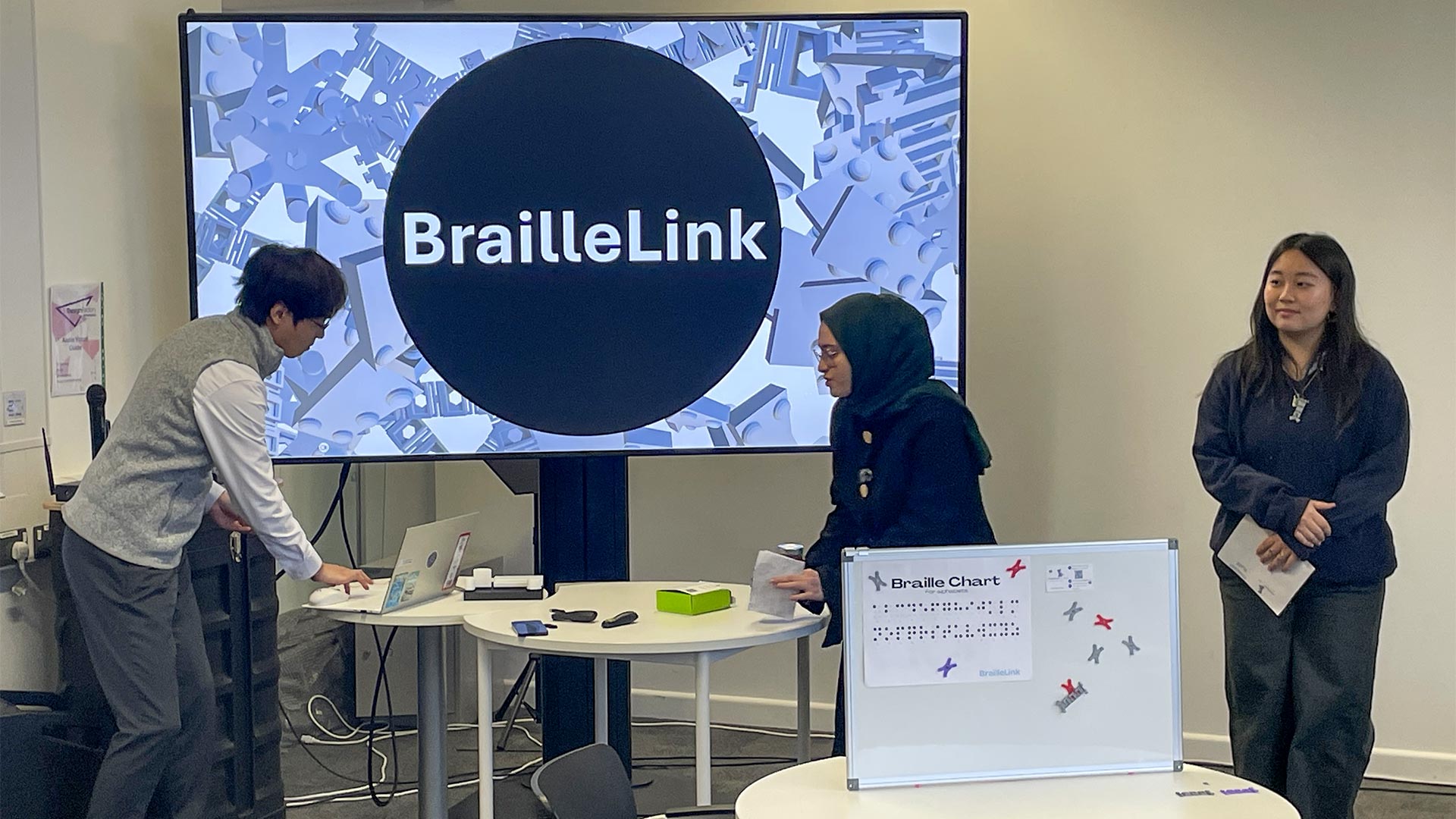 Students presenting their designs in front of a big screen