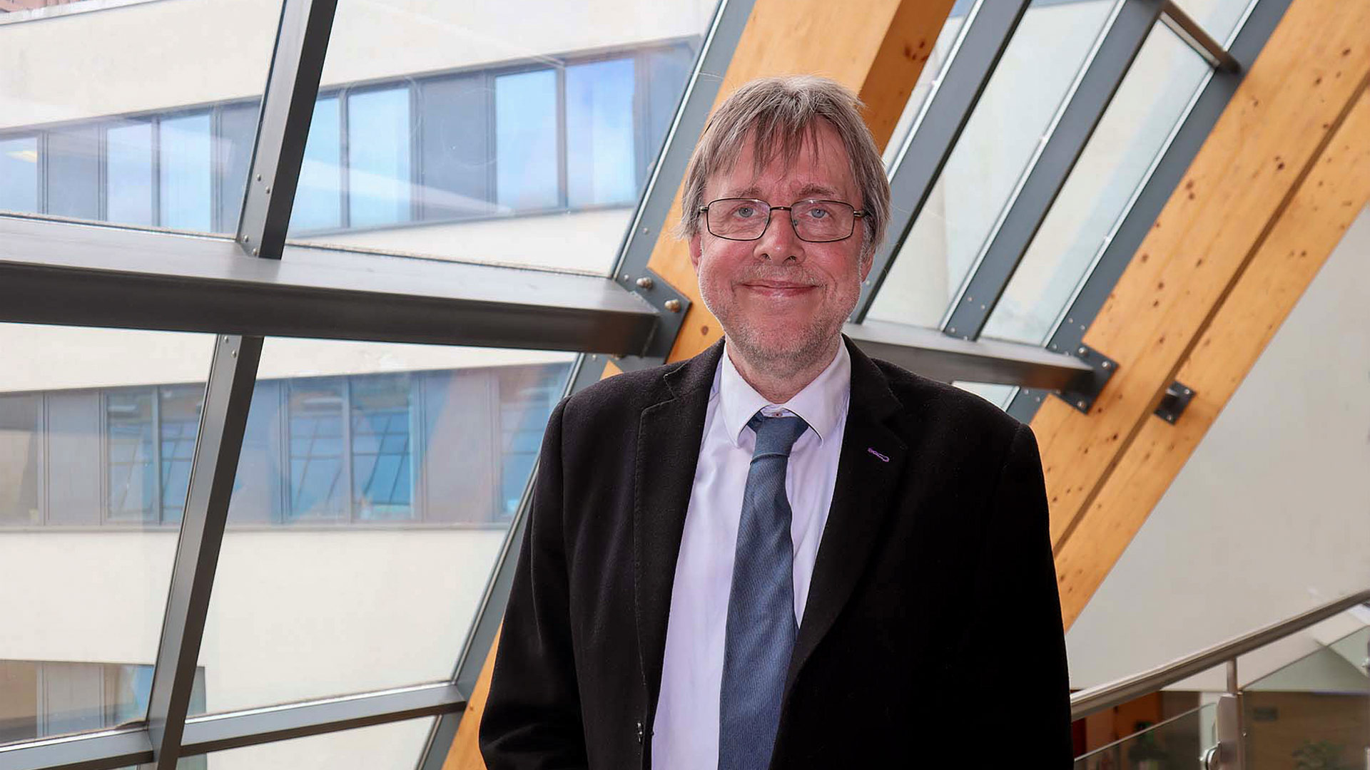 A man in a suit standing next to a window