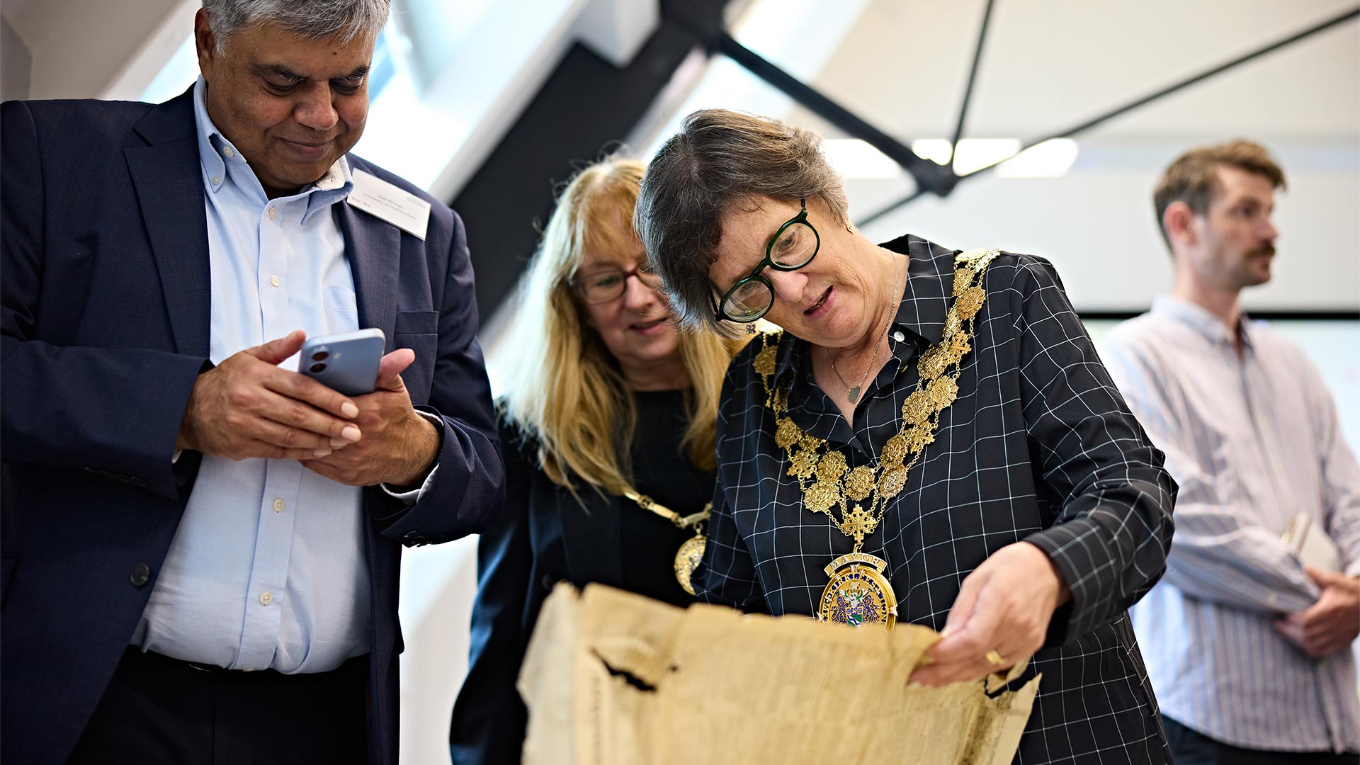 Visitors examine a historic document display during an event in a restored heritage building, with archival materials and original architectural features visible.