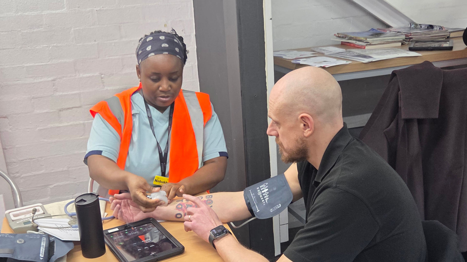 A student performs a blood pressure test on a man
