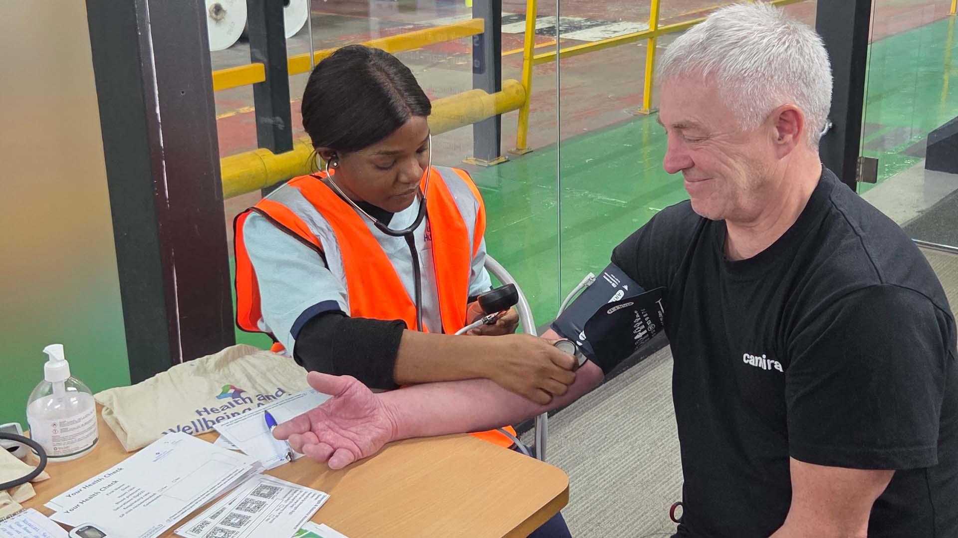 A student performs a blood pressure test on a man