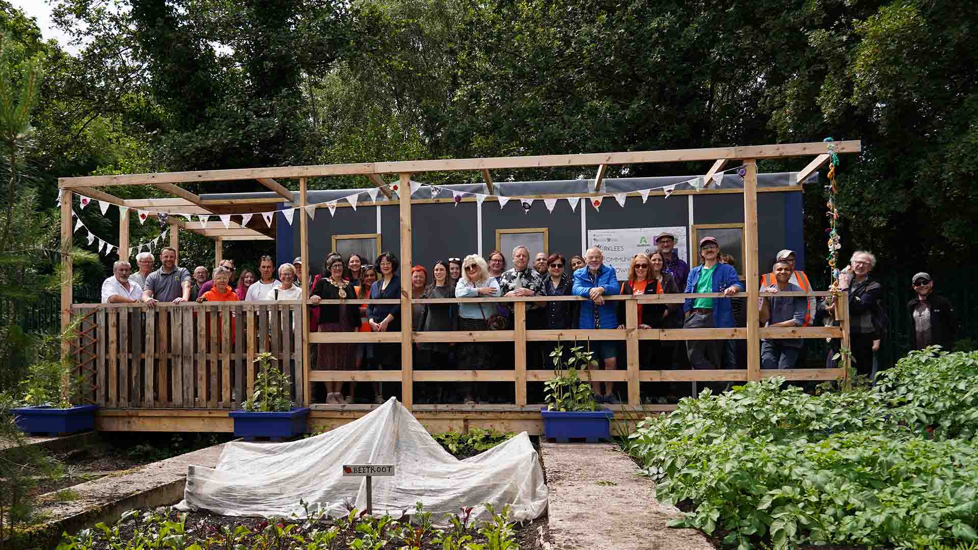 A sustainable shelter with its builders and volunteers stood in front of it