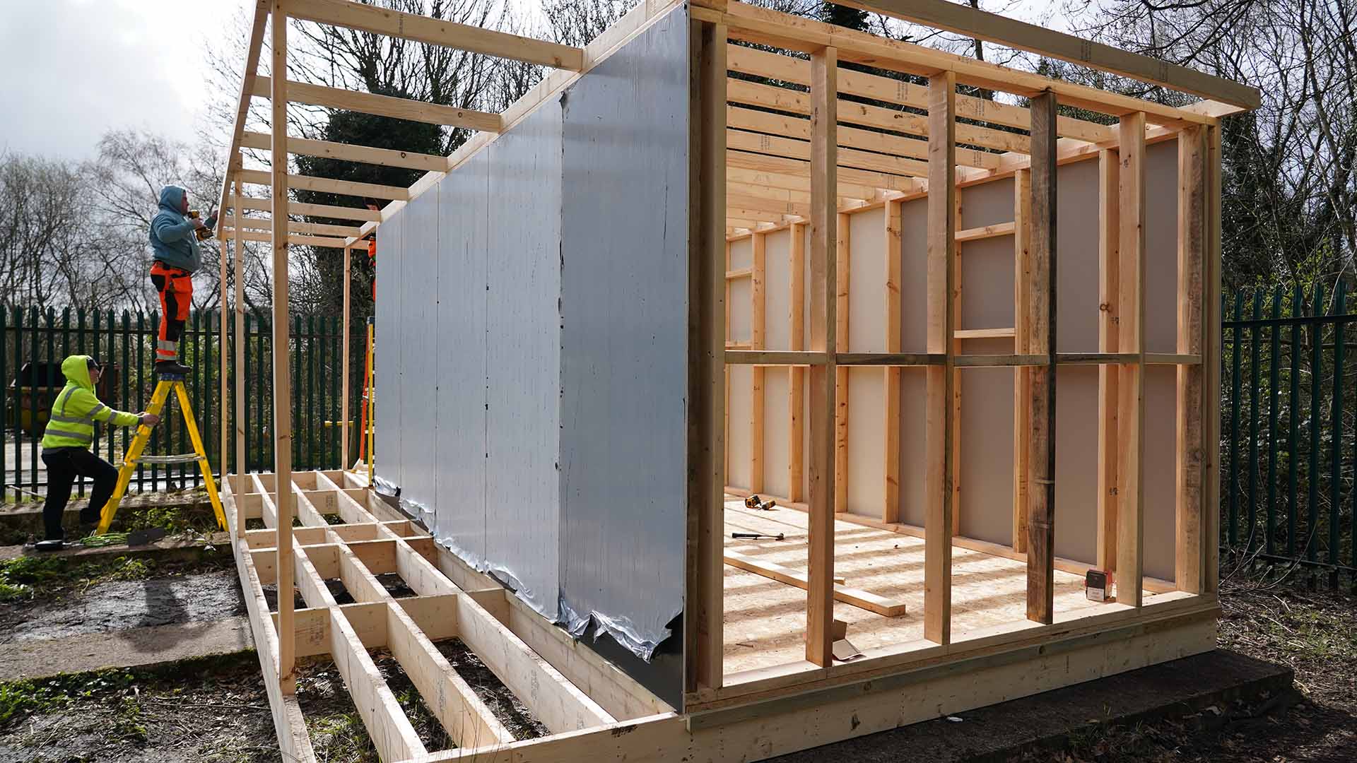 A sustainable shelter halfway through construction with some exterior panels in place.