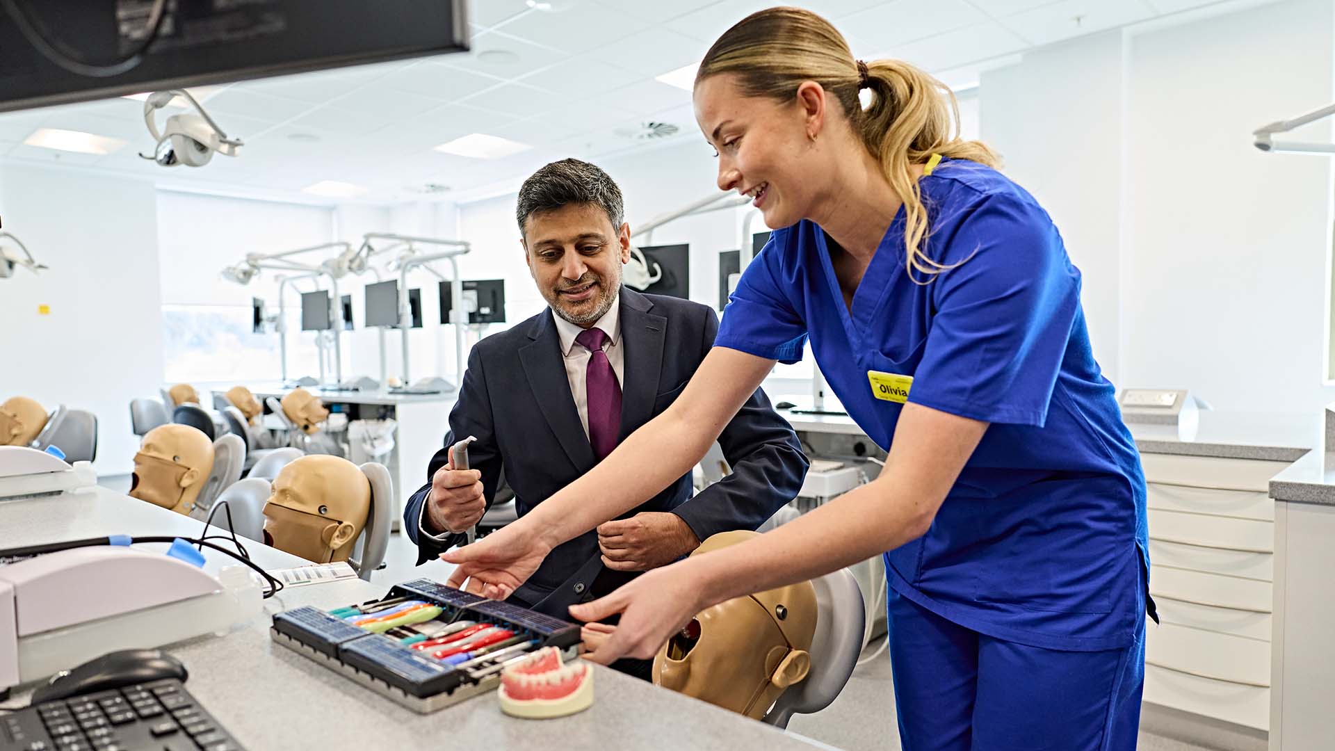 A student shows dental equipment to Dr Zubir Ahmed