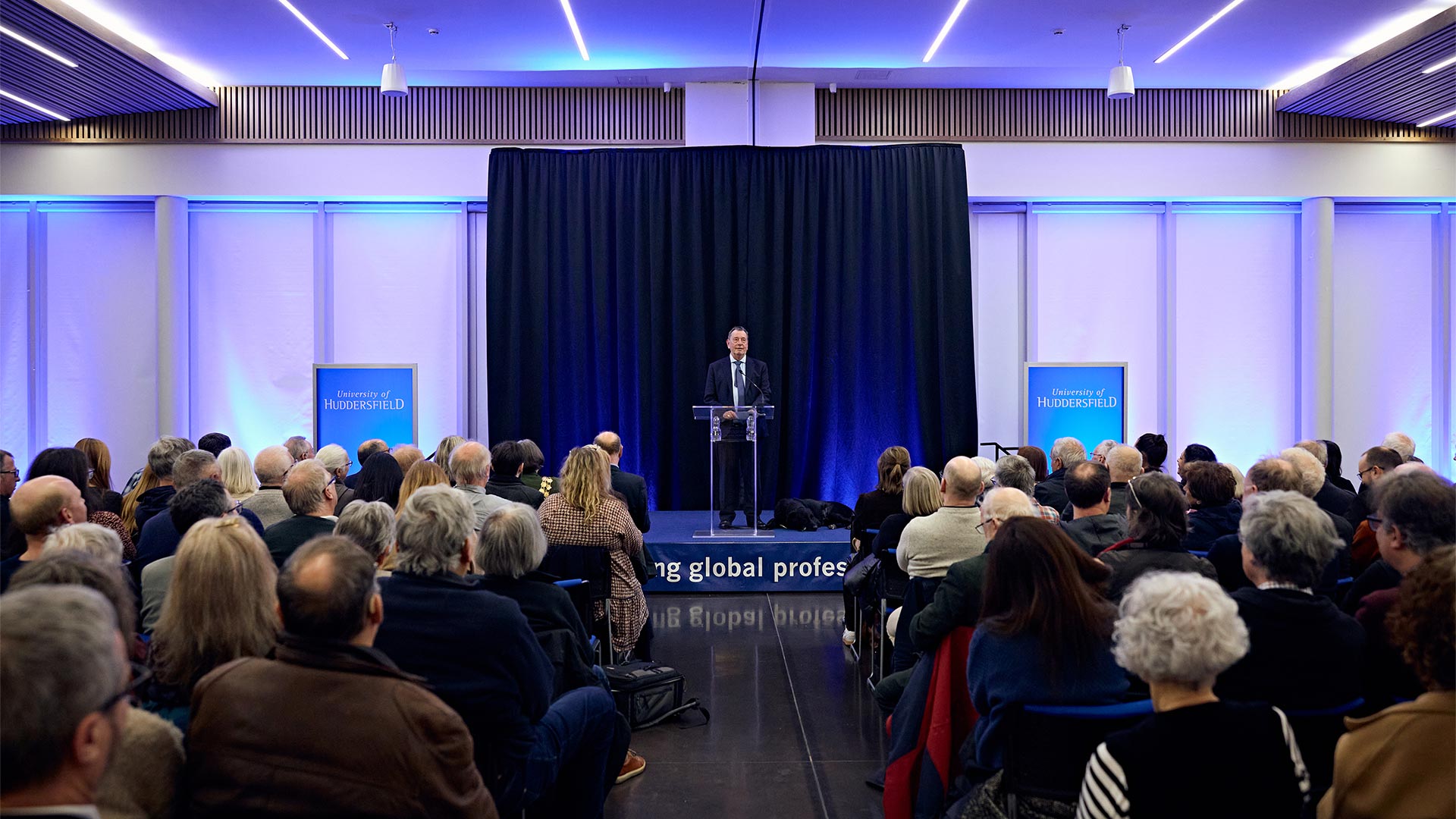 Lord David Blunkett on stage giving a lecture