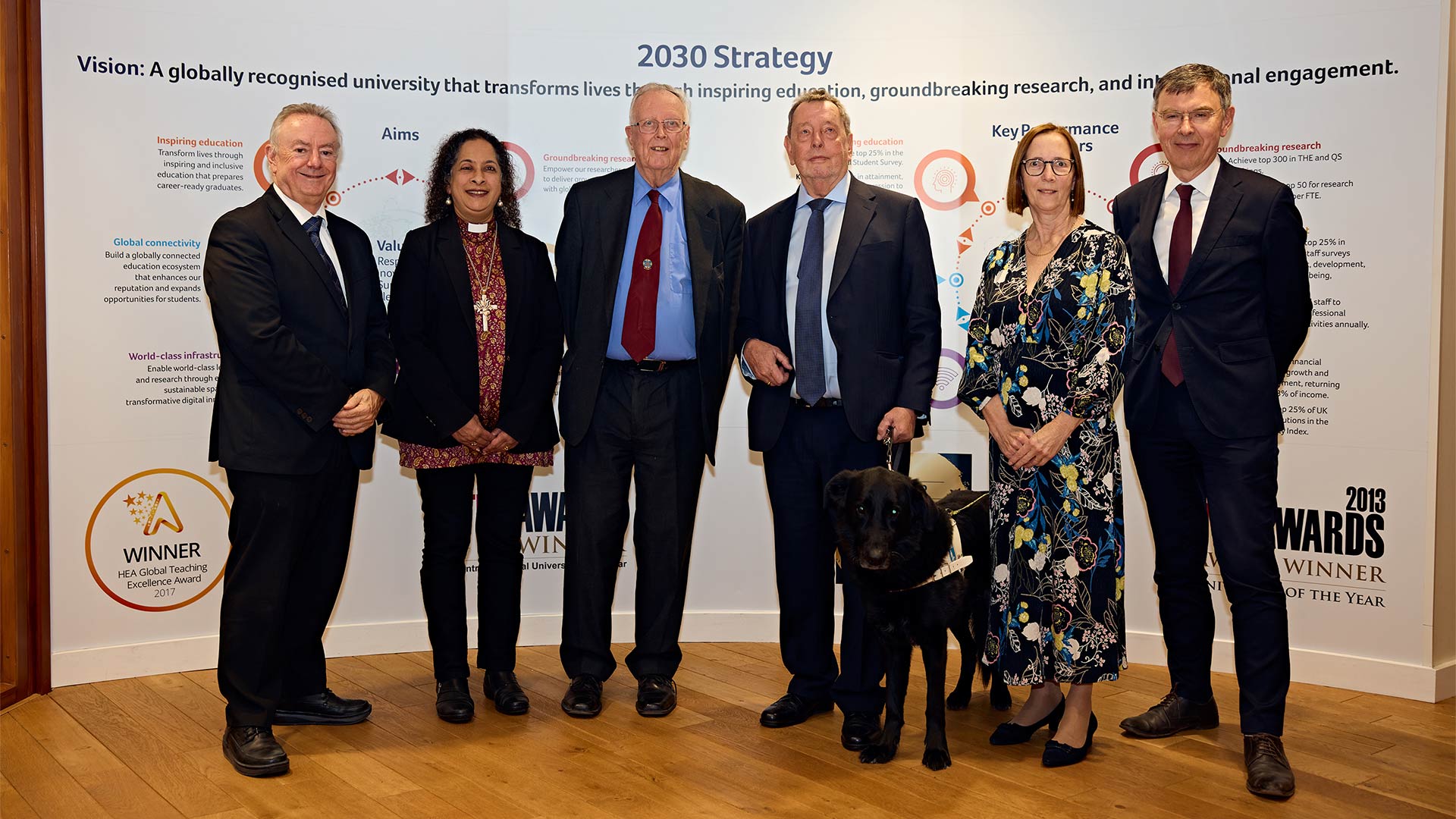 A group of men and women with a guide dog