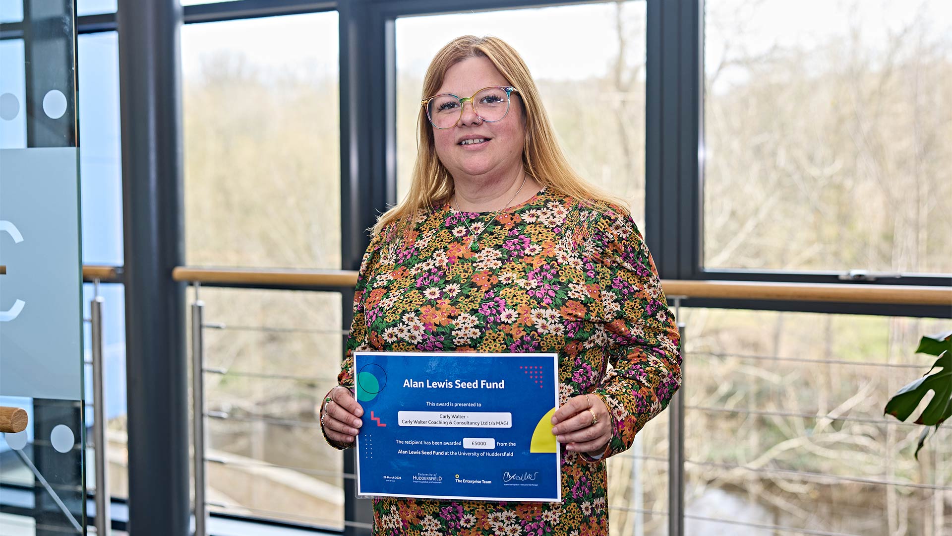 A young woman holding a certificate