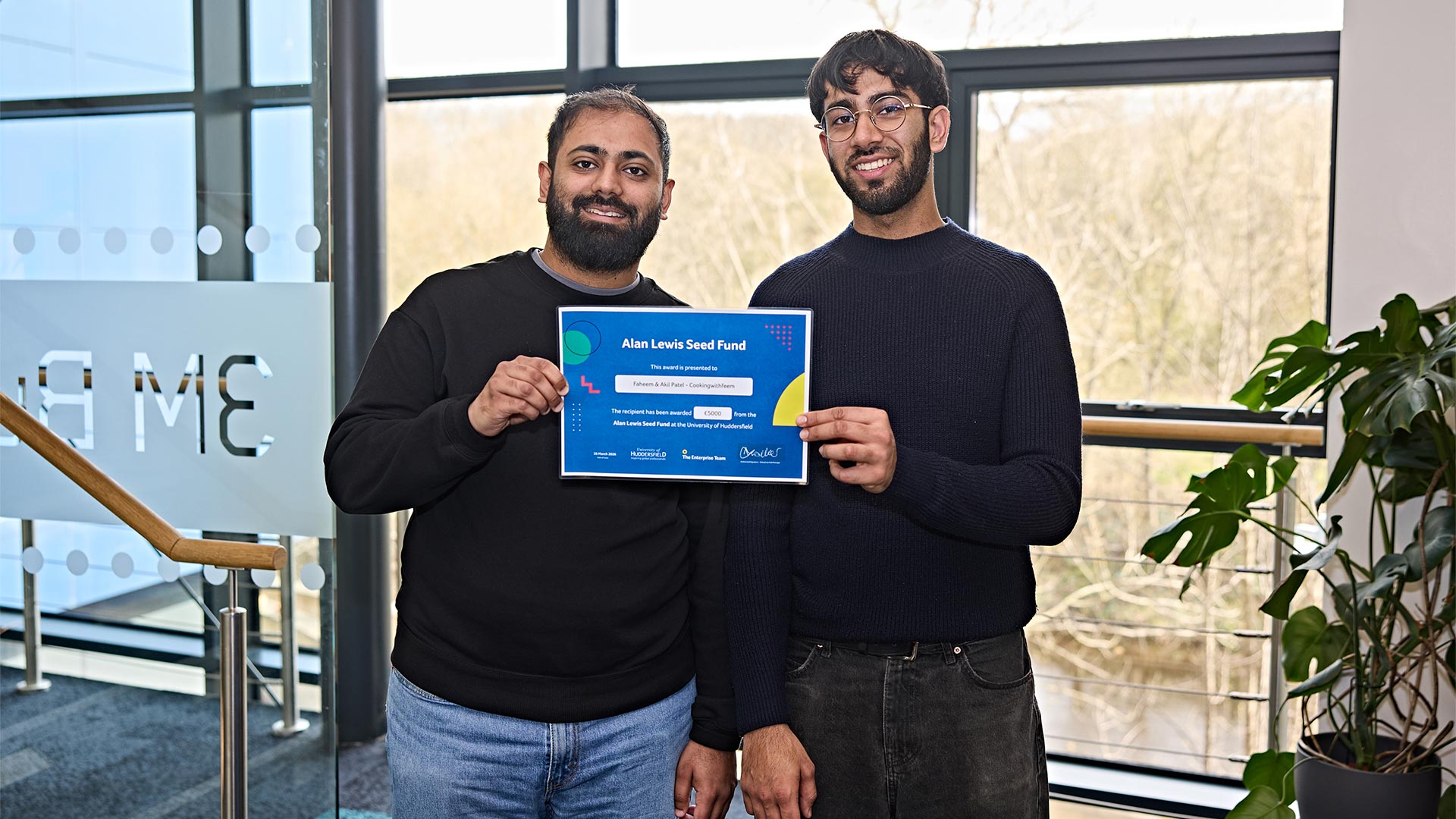 Two young men holding a certificate