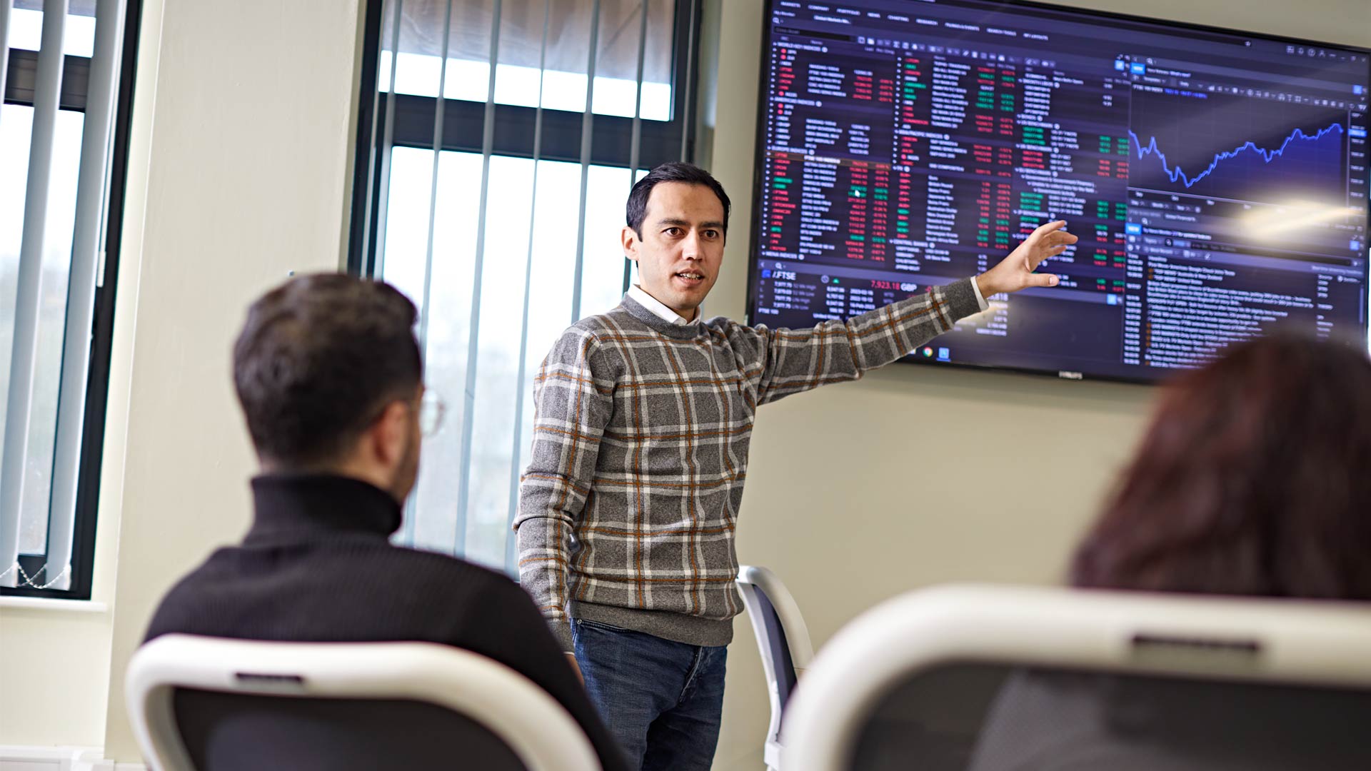 Economics classroom with demonstration of economics related systems on screen with tutorial leader