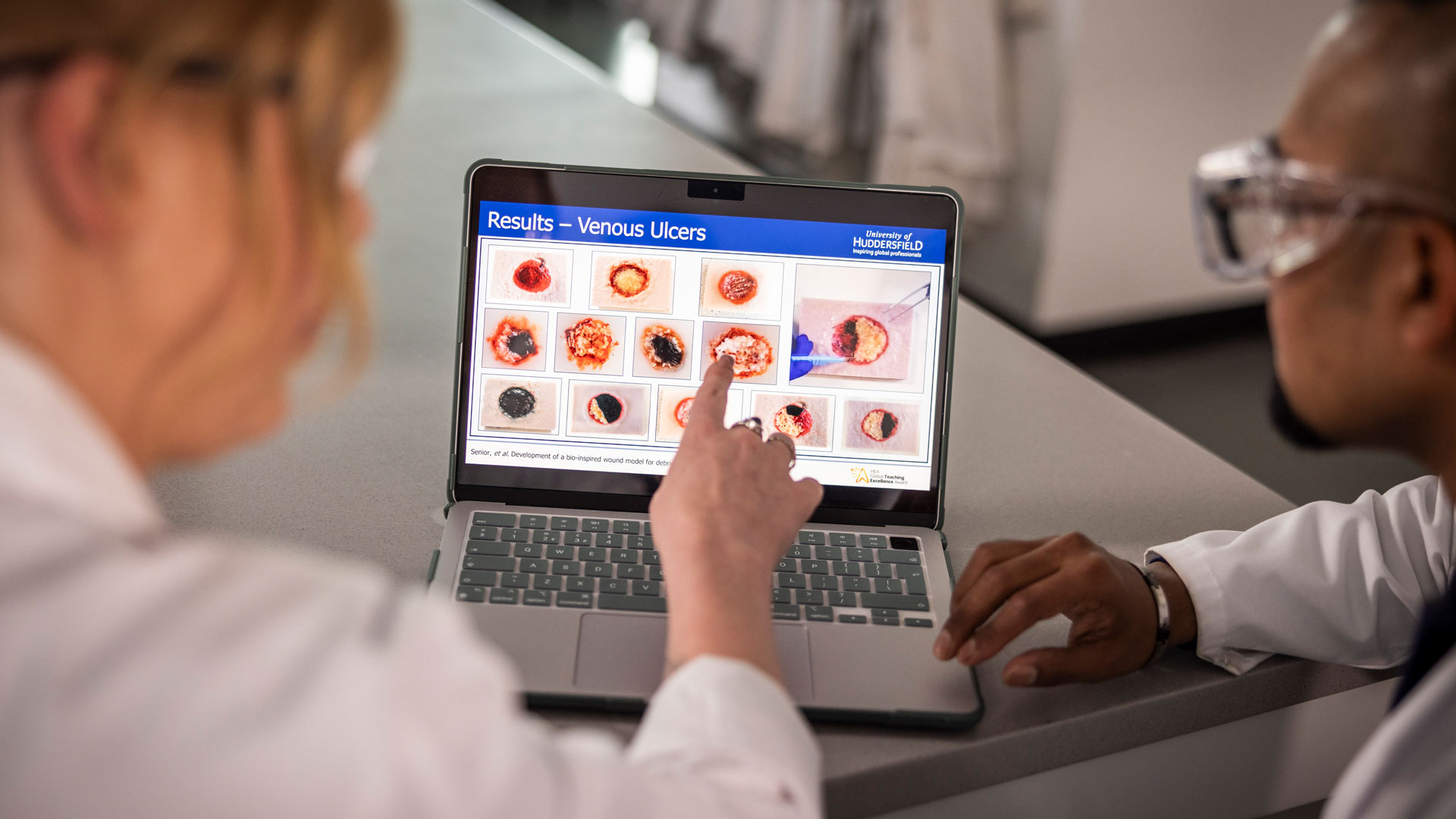 Researchers looking at wound modelling software on screen in labs