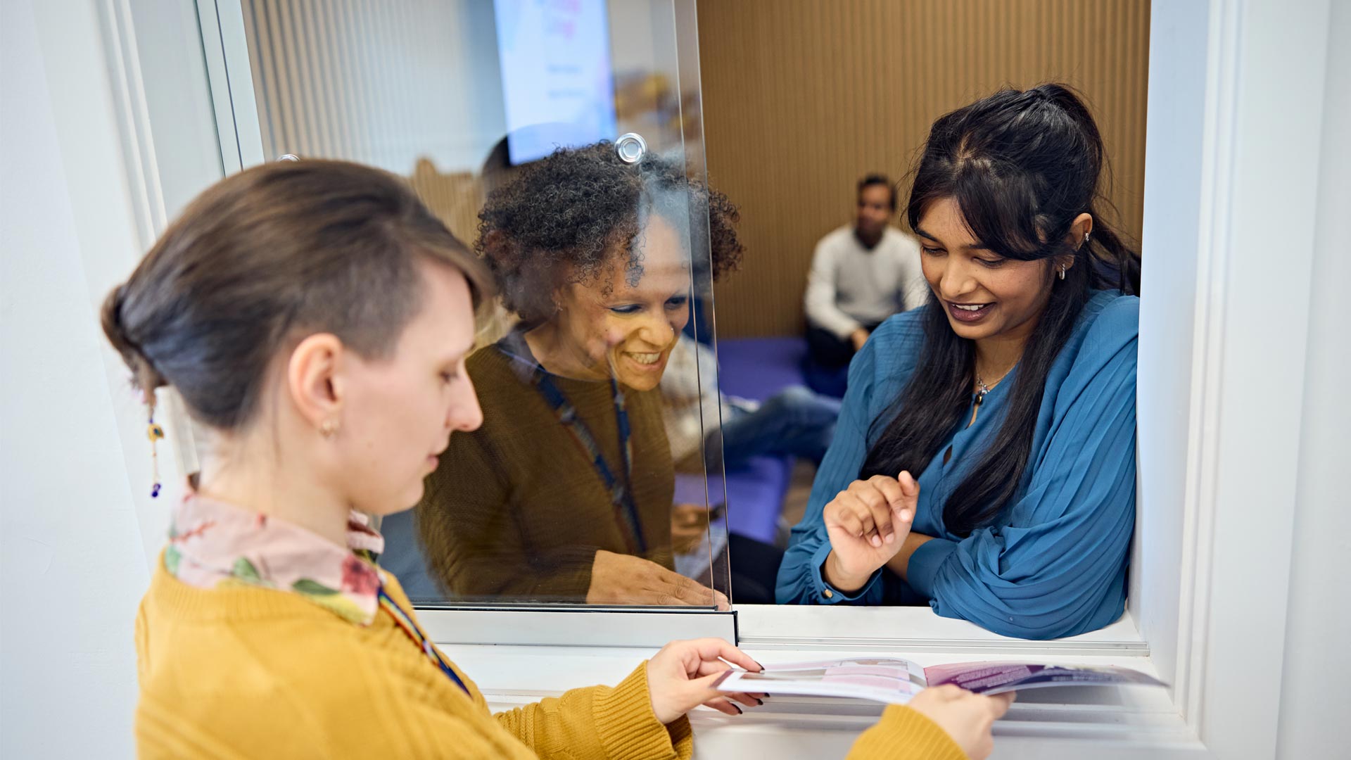 Prospective researchers chatting to staff at Doctoral College about opportunities when studying with us