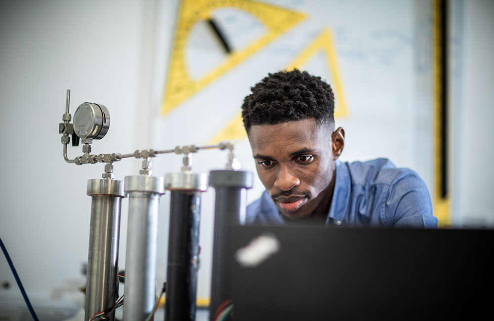 A postgraduate student looking at some equipment in a lab.