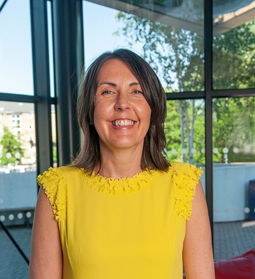 A photo of Sarah wearing yellow and smiling