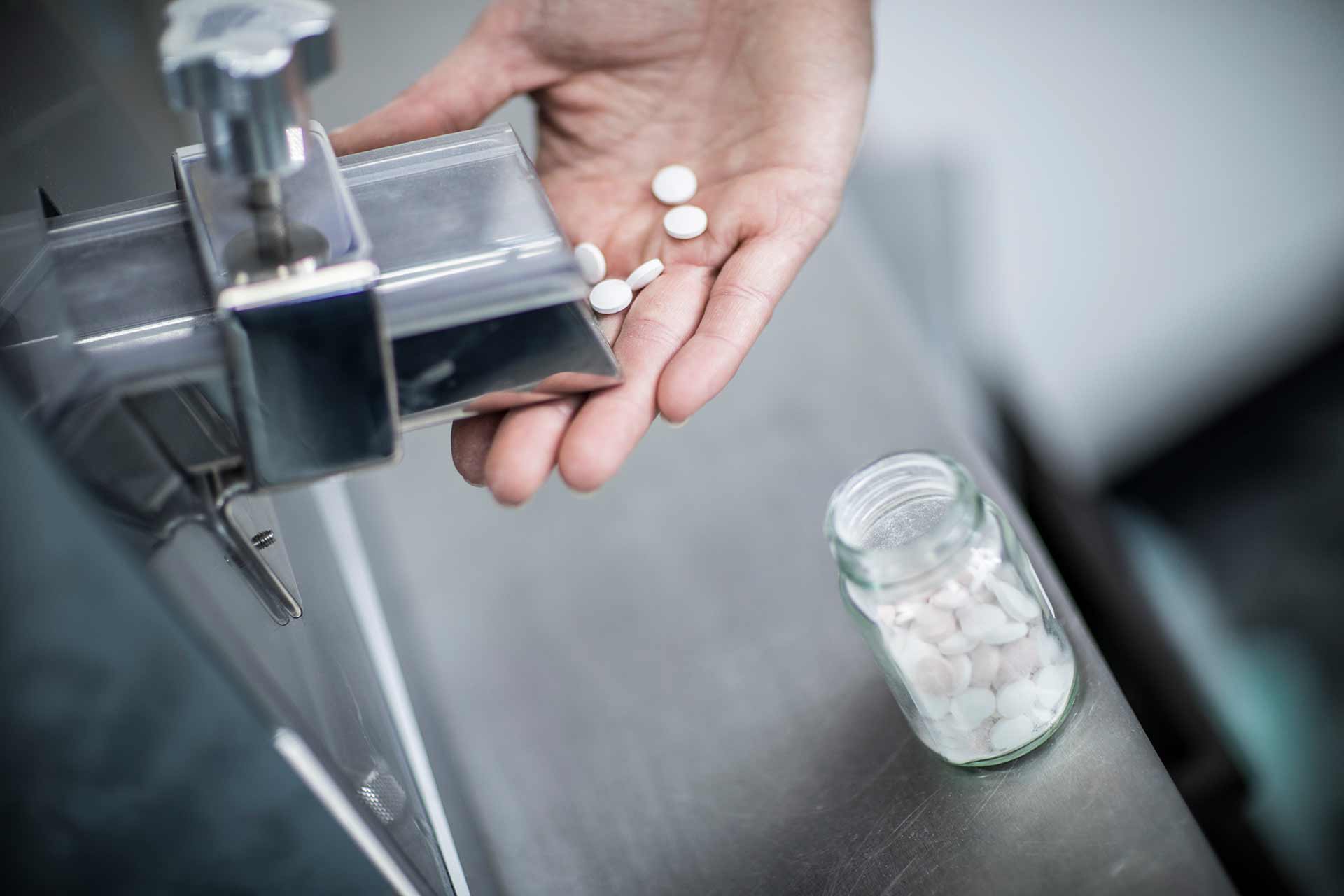 lab apparatus producing tablets, dispensed into a hand