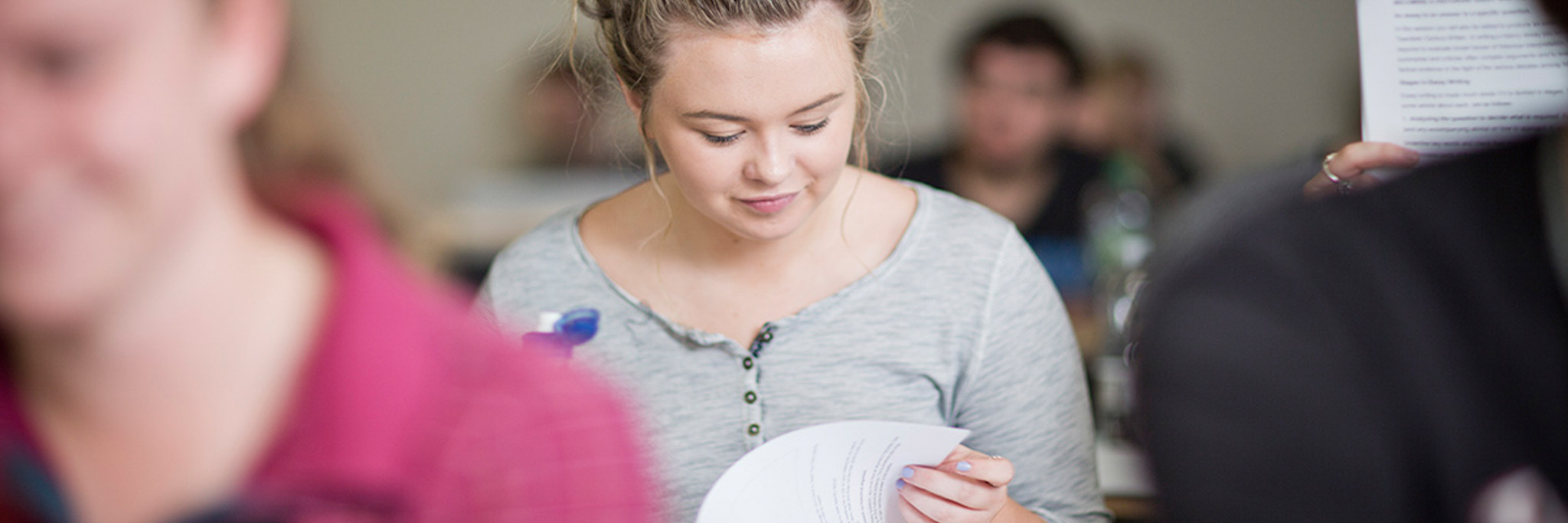 Student reading a book in a classroom