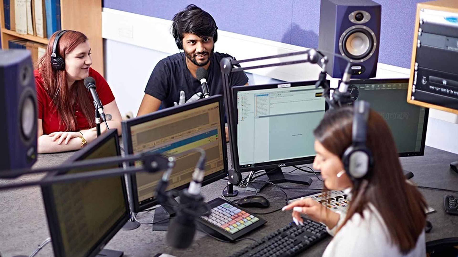 Students working and discussing in a recording studio