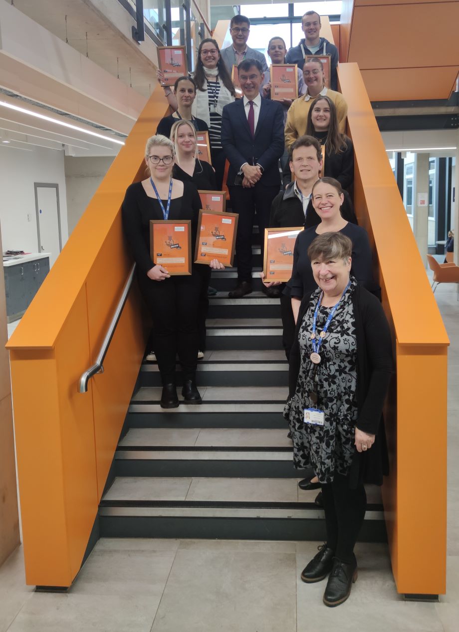 A group of people stood on a staircase holding their awards