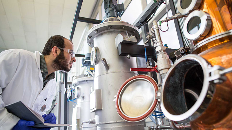 Dr Athanasios Angelis-Dimakis working in a lab with some large metal machinery..