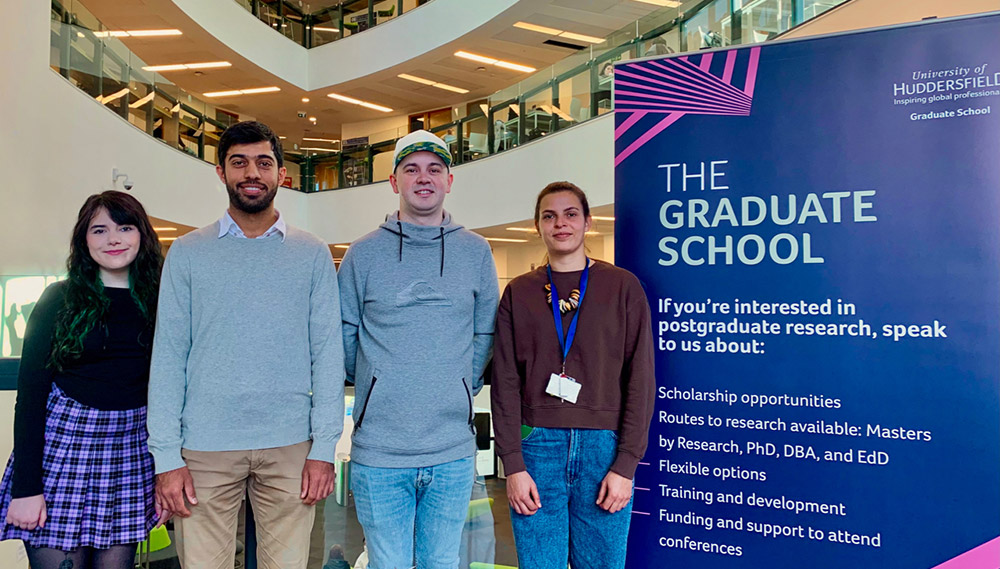HEA Fellowship recipients Iona Murphy, Omar Alshaikh, Jonathan Hawkins and Ana Mendes-Texeira stood next to a Graduate School pull up banner.