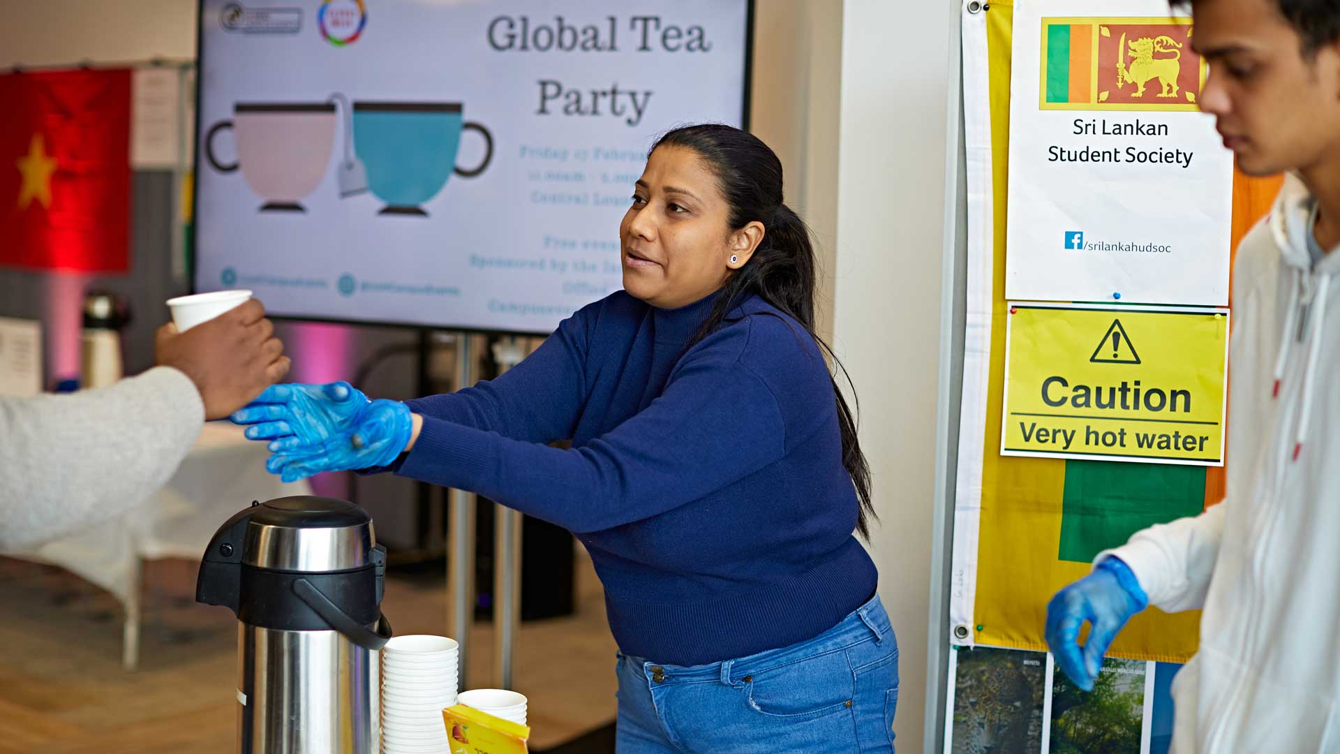a student handing out a cup of tea