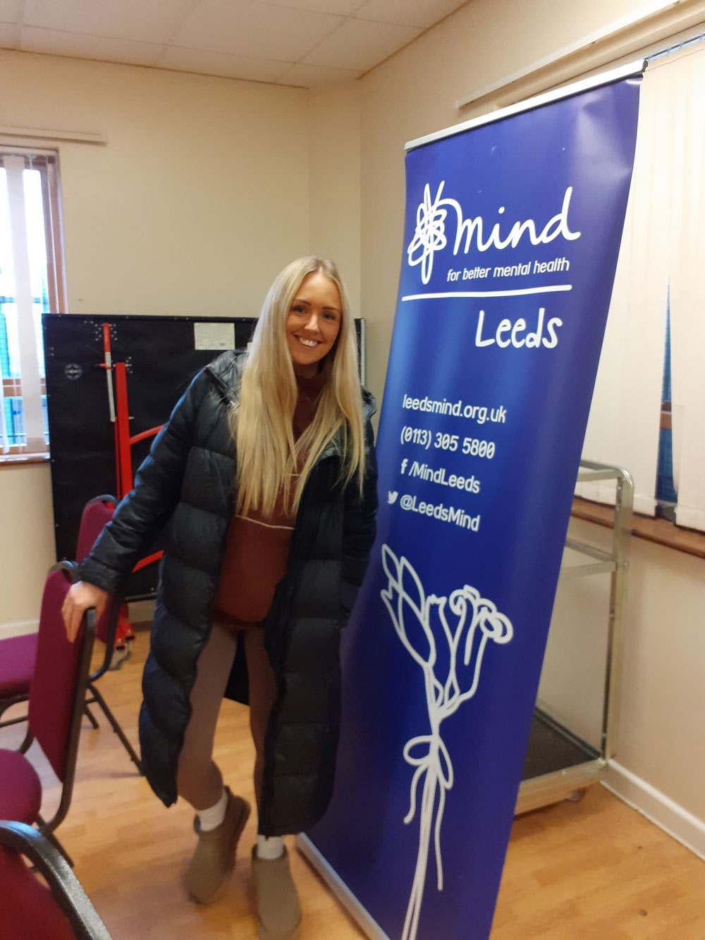 a photo of jess next to a mind charity banner